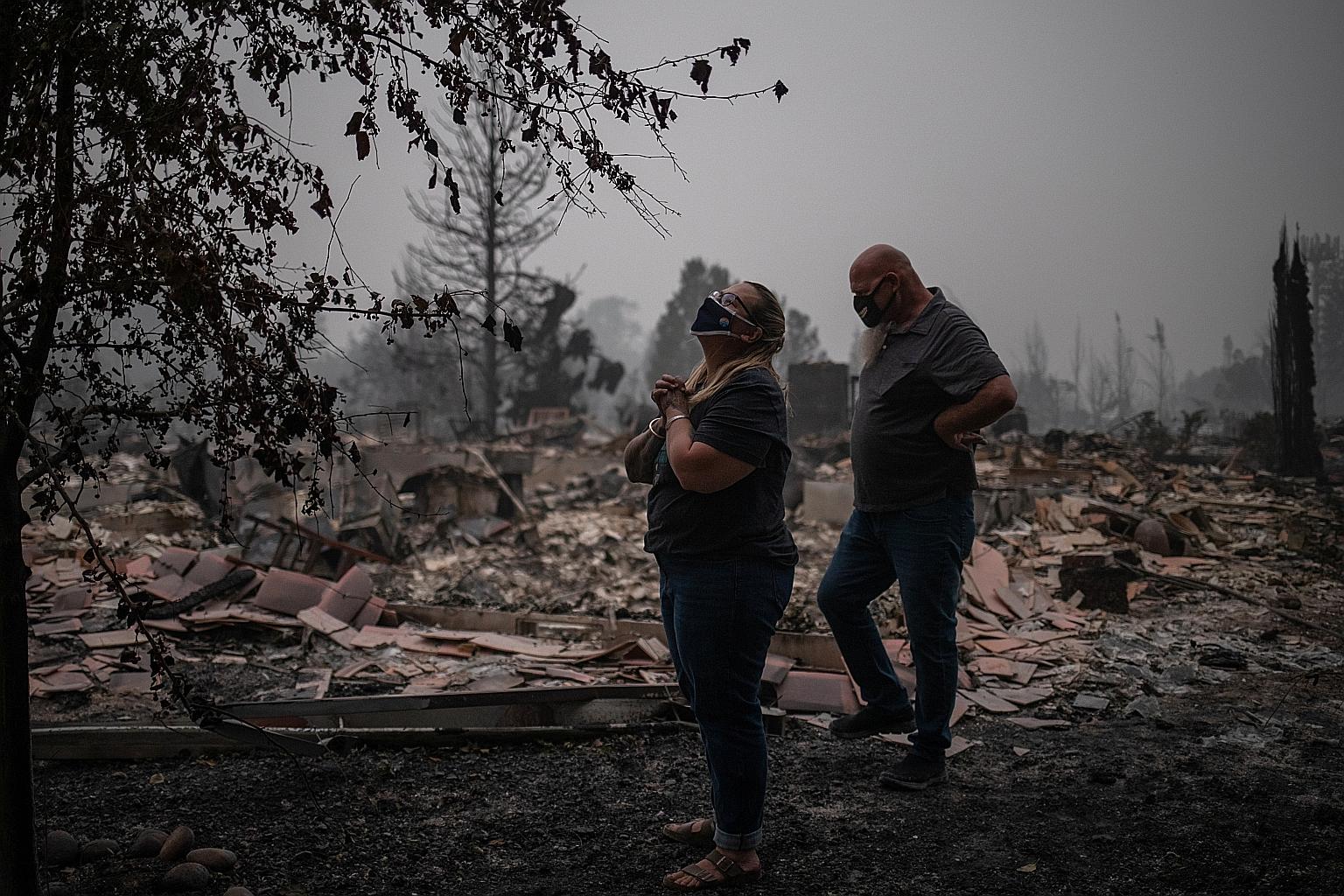 A couple on the site of their fire-gutted home in Talent, Oregon, last Saturday. A blitz of wildfires across Oregon, California and Washington states has destroyed thousands of homes and a half dozen small towns this summer, killing more than two doz