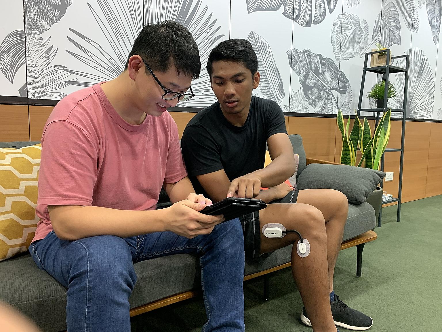 National University of Singapore graduates and co-inventors of Kimia, Mr Ricky Guo and Mr Aaron Ramzeen, testing the accuracy of their knee rehabilitation device (seen here on Mr Ramzeen's leg). PHOTO: DYSON SINGAPORE