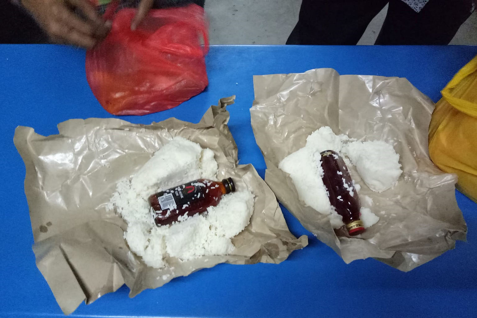 Above: Liquor bottles found hidden in food packets in a reported attempt last month by migrant workers staying in Sungei Tengah Lodge to smuggle in alcohol on their return from work. Right: