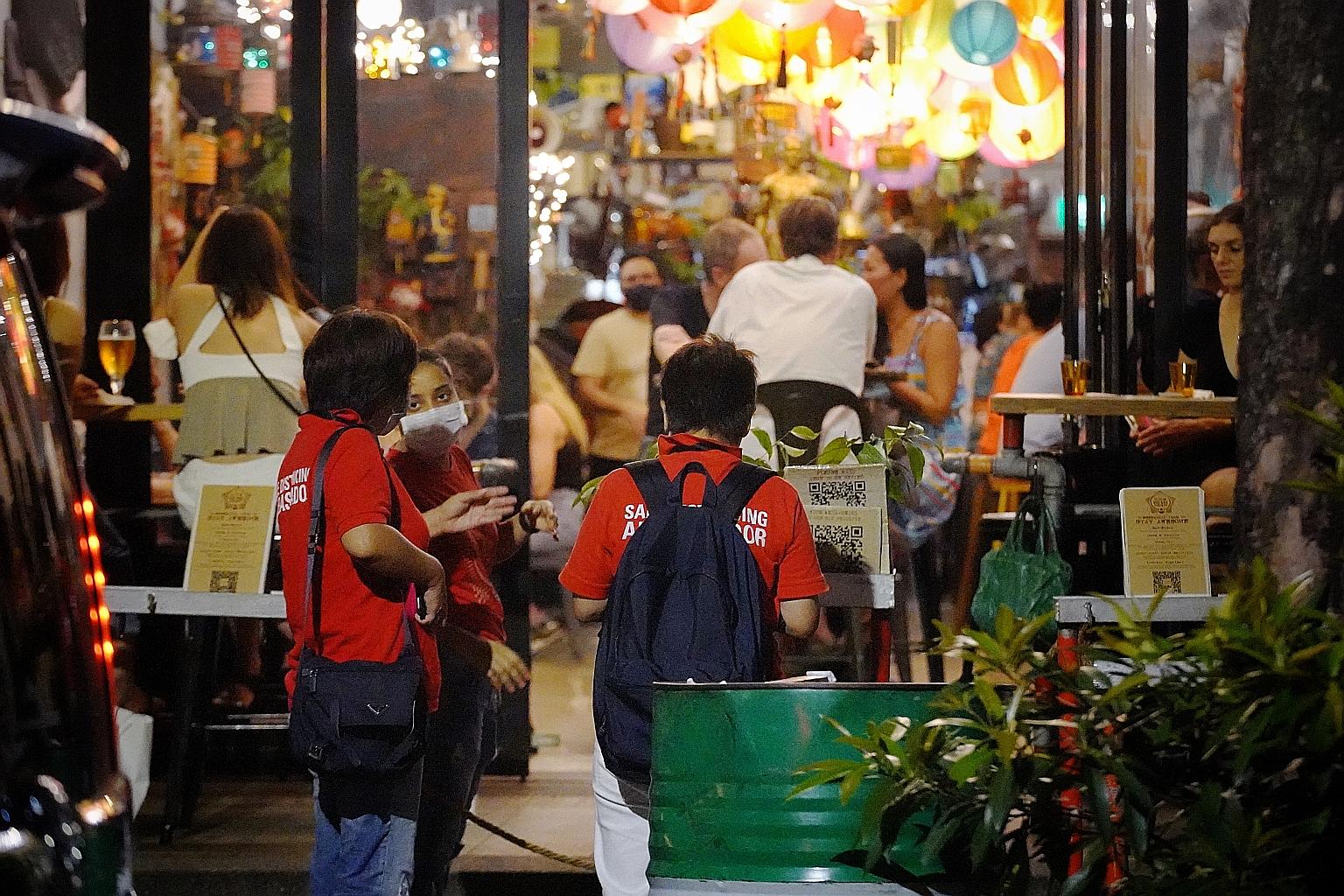 Safe distancing ambassadors speaking to a staff member of a restaurant in Telok Ayer Street on Friday.