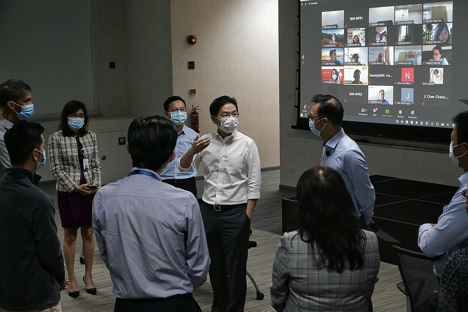 Education Minister Lawrence Wong speaking to IBM Singapore managing director Martin Chee at the company's premises in Changi Business Park yesterday. IBM's programme is part of a larger government effort by SkillsFuture Singapore to provide 30,000 tr