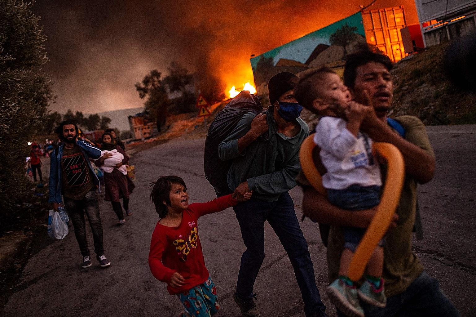 A family of migrants fleeing the Moria camp on the Greek island of Lesbos on Sept 9 after a fire broke out. European Union countries have long been at loggerheads over how to handle the influx of migrants.
