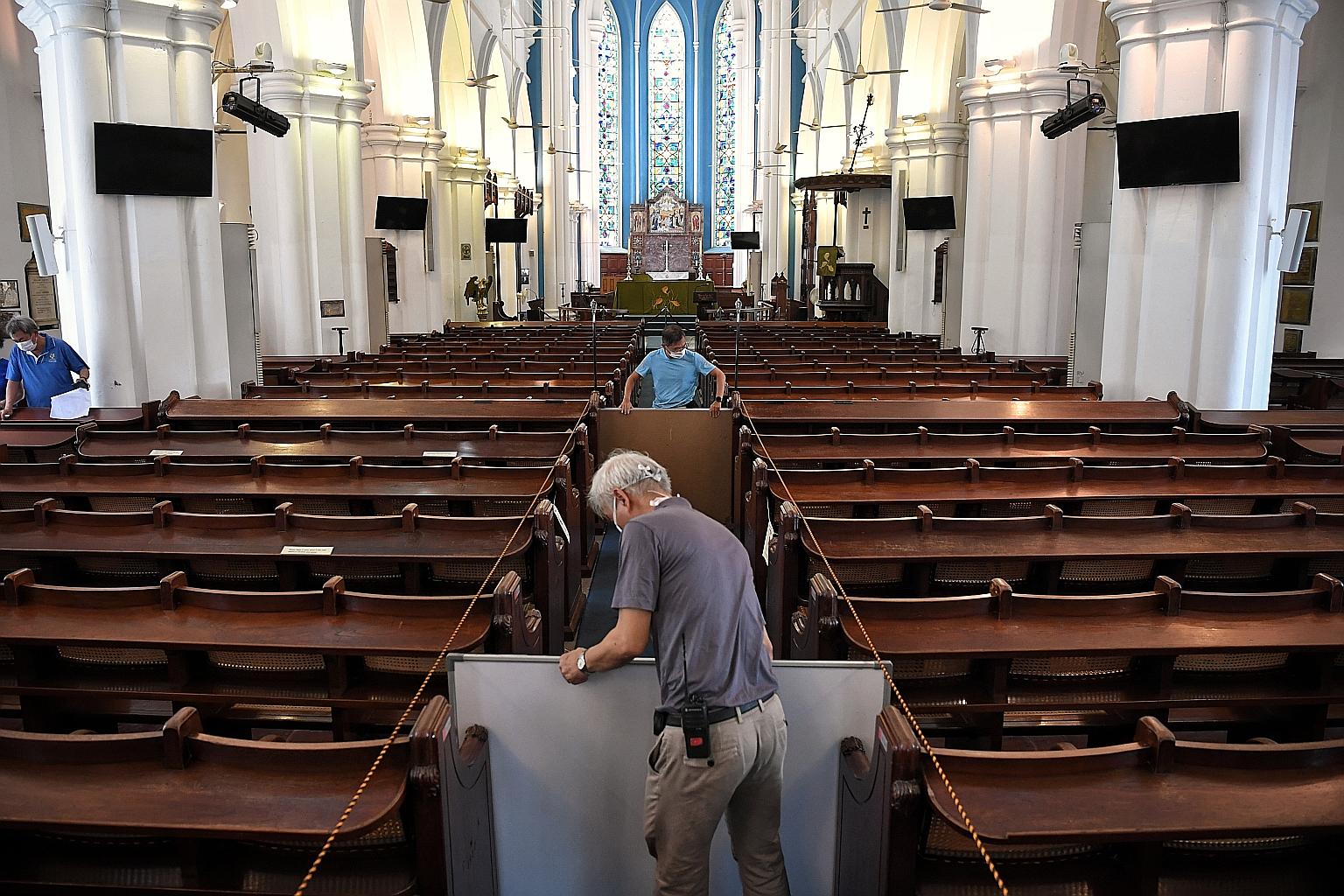 Church staff putting up temporary boards at St Andrew's Cathedral last month to prepare for reopening for a weekend service. The church was among some religious organisations which were allowed to hold gatherings of up to 100 people under a pilot sch