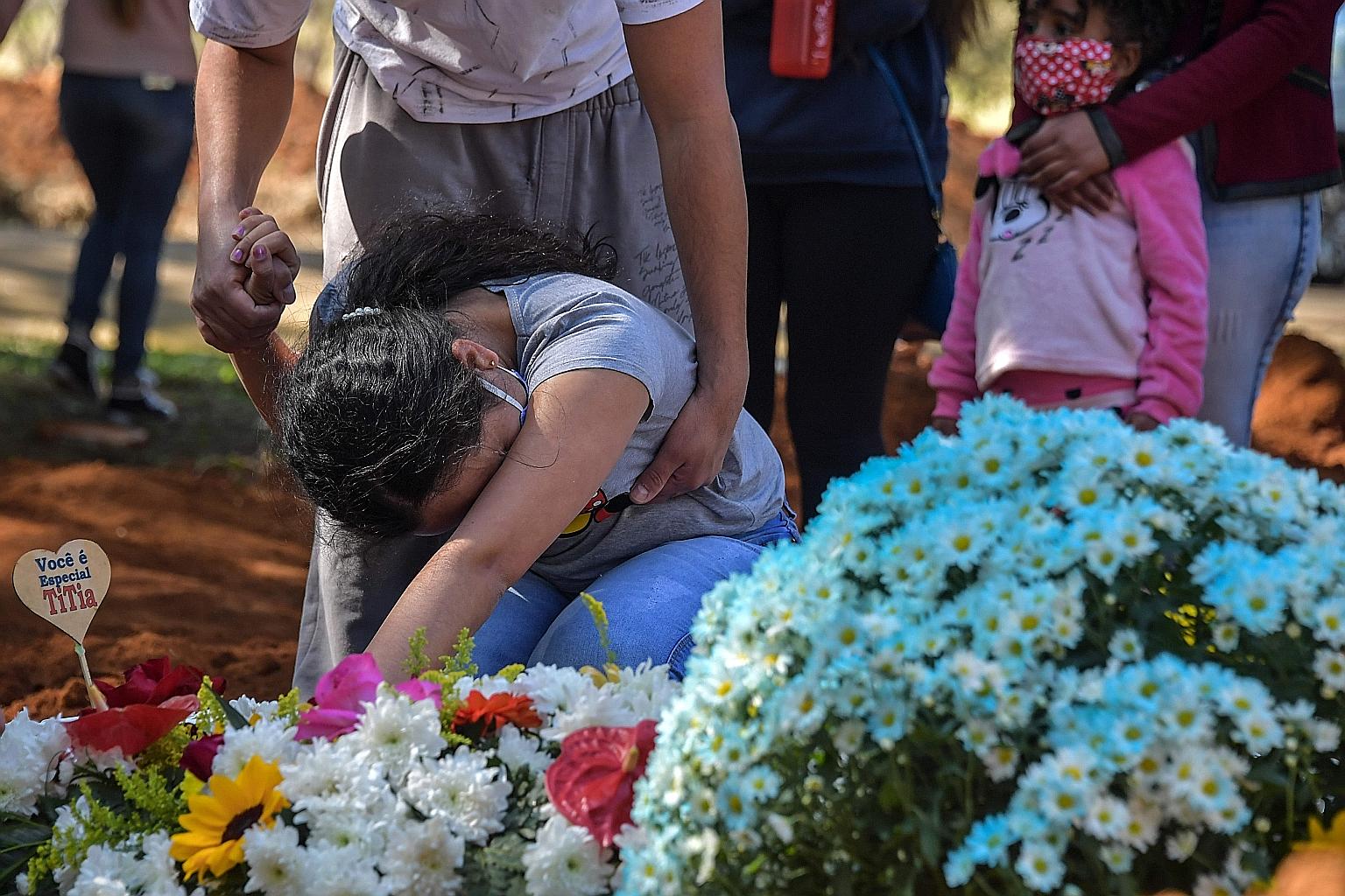 ARGENTINA: Healthcare workers in Buenos Aires observing a minute of silence for colleagues who died from Covid-19, in a protest to demand better working conditions last month. Argentina has had over 14,700 deaths. PERU: Ms Liset Diaz, 35, holding a p