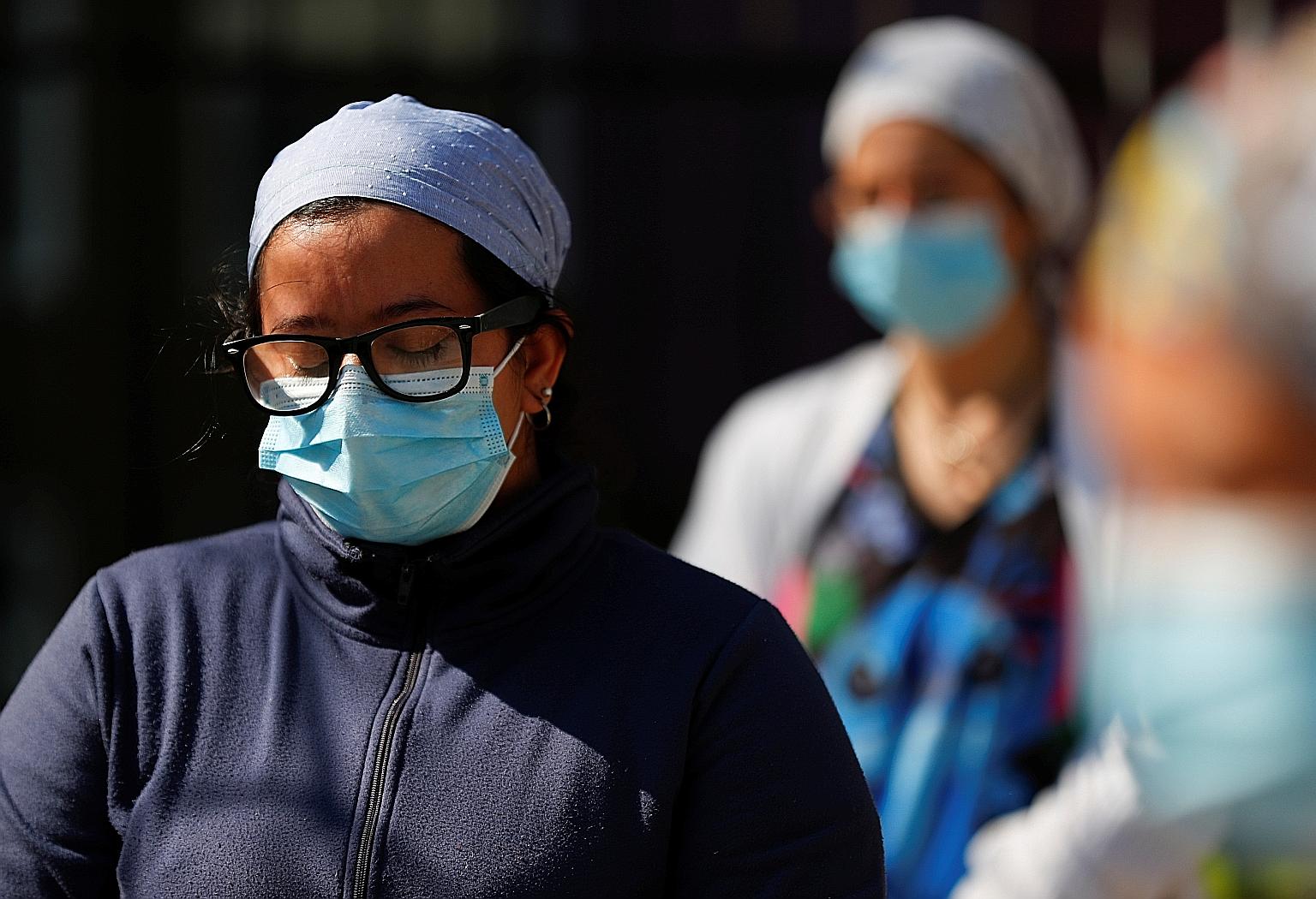 ARGENTINA: Healthcare workers in Buenos Aires observing a minute of silence for colleagues who died from Covid-19, in a protest to demand better working conditions last month. Argentina has had over 14,700 deaths. PERU: Ms Liset Diaz, 35, holding a p