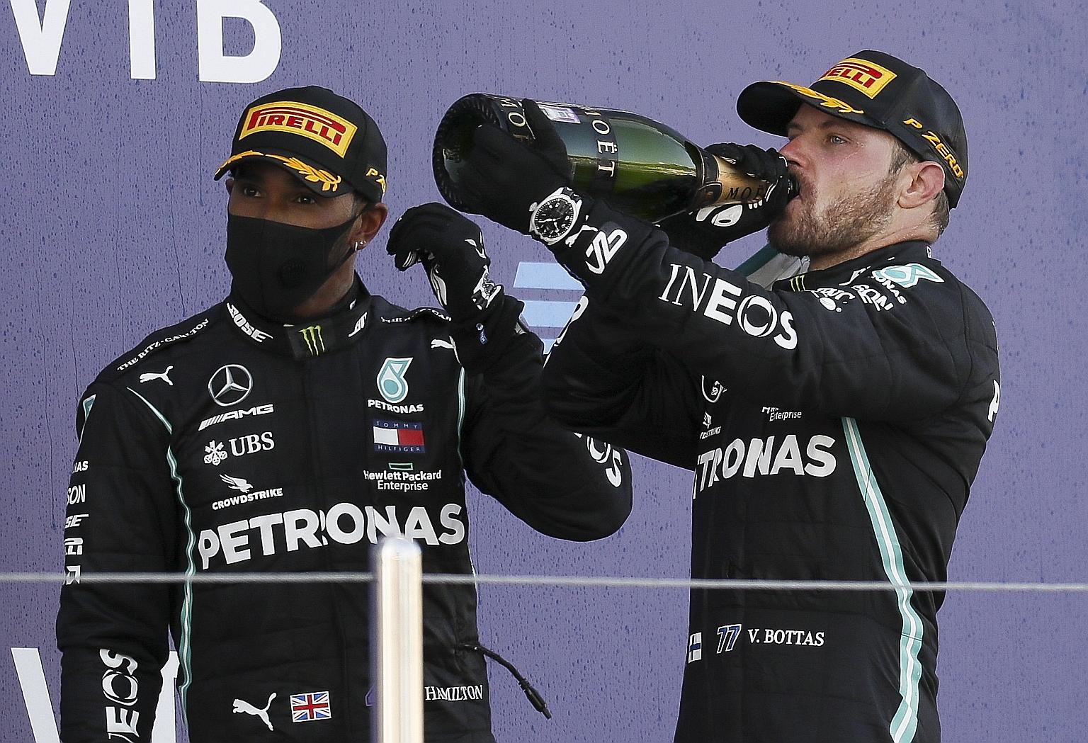 A frustrated Lewis Hamilton on the Sochi podium yesterday, while Mercedes teammate toasted his second Russian Grand Prix title which cut the deficit in the drivers' race to 44 points. PHOTO: EPA-EFE