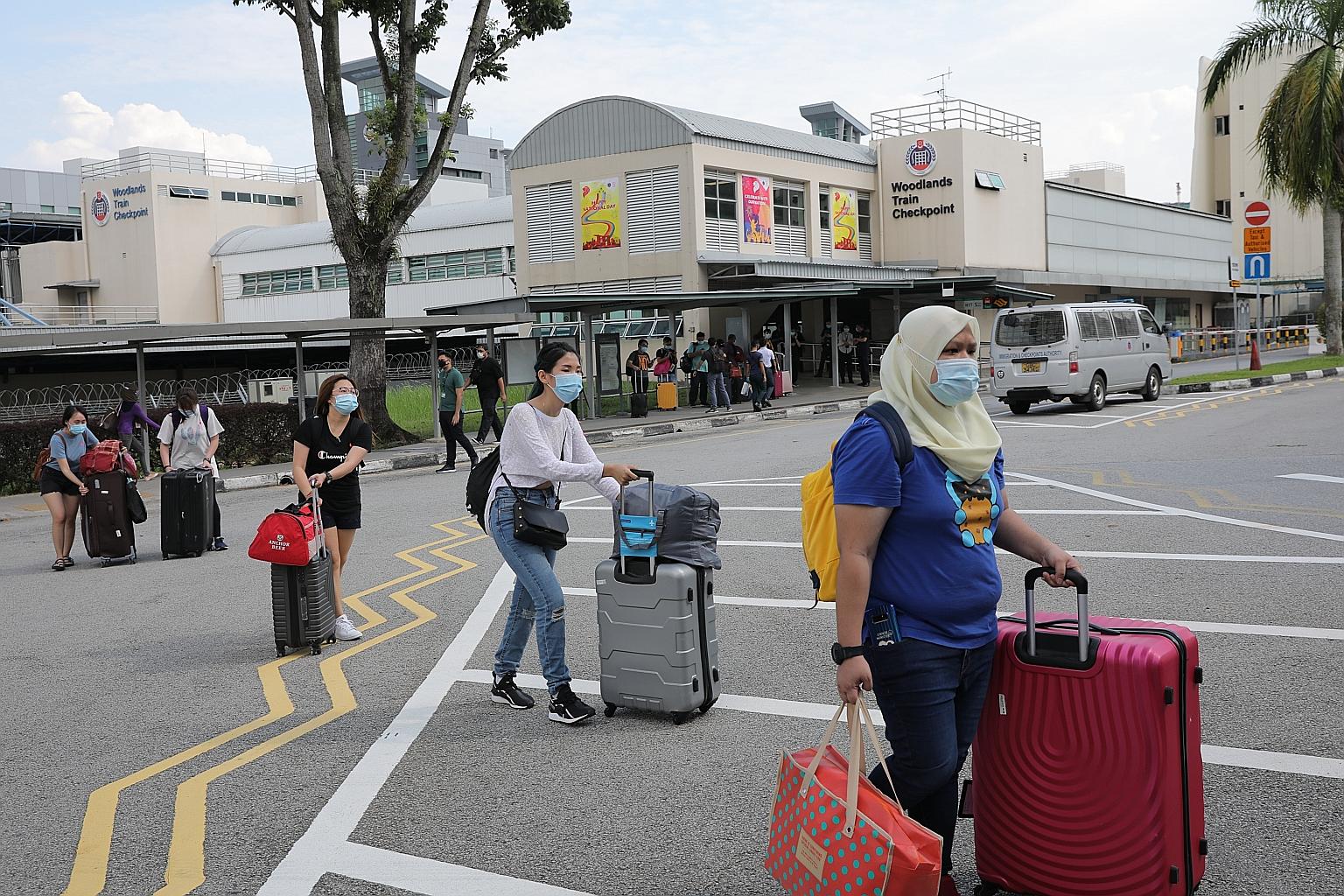 Workers arriving at the Woodlands Train Checkpoint from Malaysia on Aug 17, when cross-border travel resumed. The partial reopening of borders has brought relief to firms in Singapore facing labour shortages. ST PHOTO: ONG WEE JIN