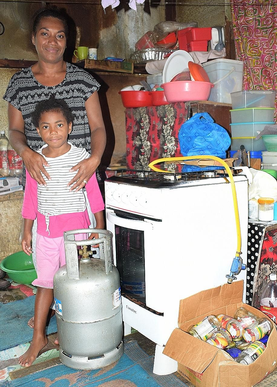 Right and far right: Ms Temalesi Tauga with her six-year-old daughter Keran Alice at their Kalekana home in the Fijian capital city of Suva. Ms Tauga now has an almost-new stove, a full cylinder of gas and ingredients to start a baking business, afte