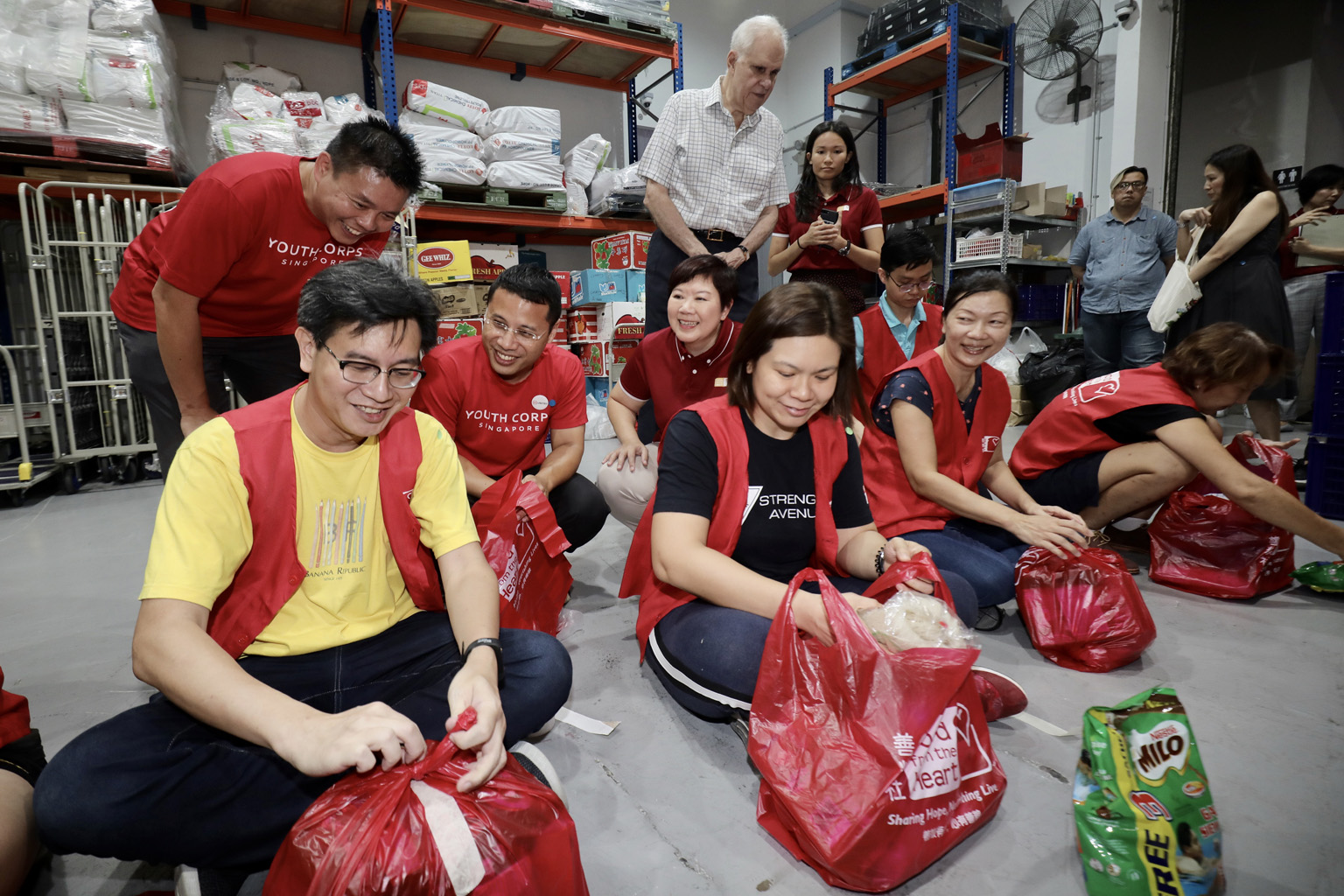 Mr Desmond Lee (in red, squatting), who is now National Development Minister and co-chairman of the Emerging Stronger Task Force, launching the SGUnited Portal, which brings together community-led Covid-19 responses, in February. LIANHE ZAOBAO FILE P