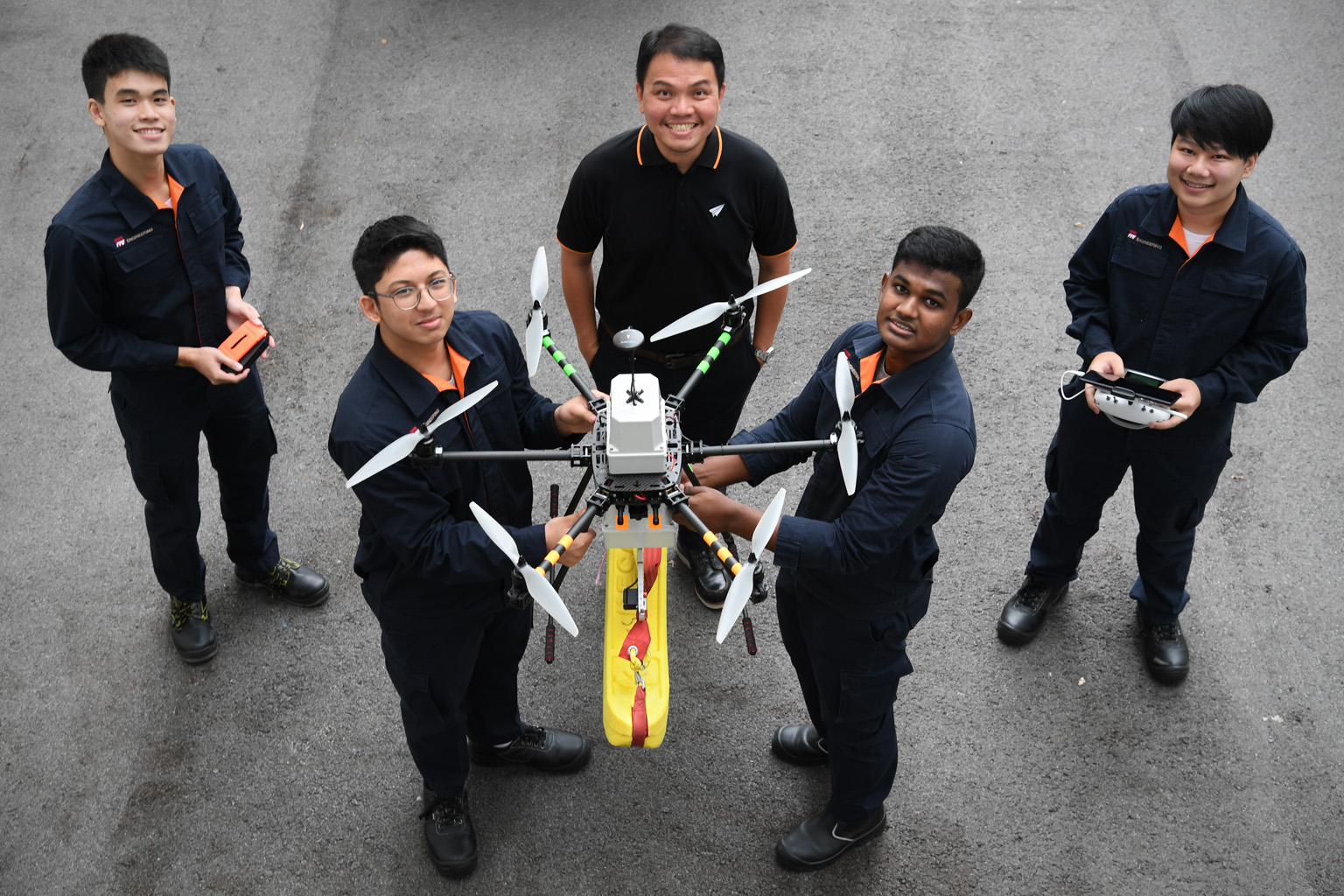 ITE aerospace avionics lecturer Soh Kee Teck (centre) and students (from left) Stephen Ong, Erhan Harith Abdul Malik, Sanjay Shagaran and Kenneth Ng with a drone they are developing to patrol beaches. It carries a float that can be dropped near a swi