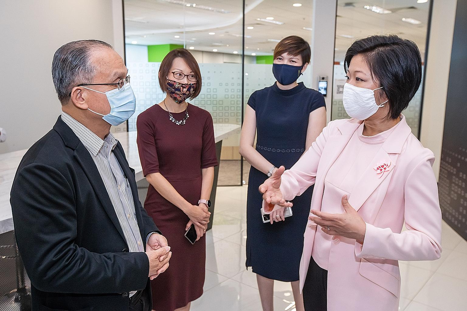 Senior Minister of State for Communications and Information and National Development Sim Ann speaking with QSS managing director Simon Quek Hong Kiat at the launch of OneSME yesterday. Also present were Infocomm Media Development Authority assistant