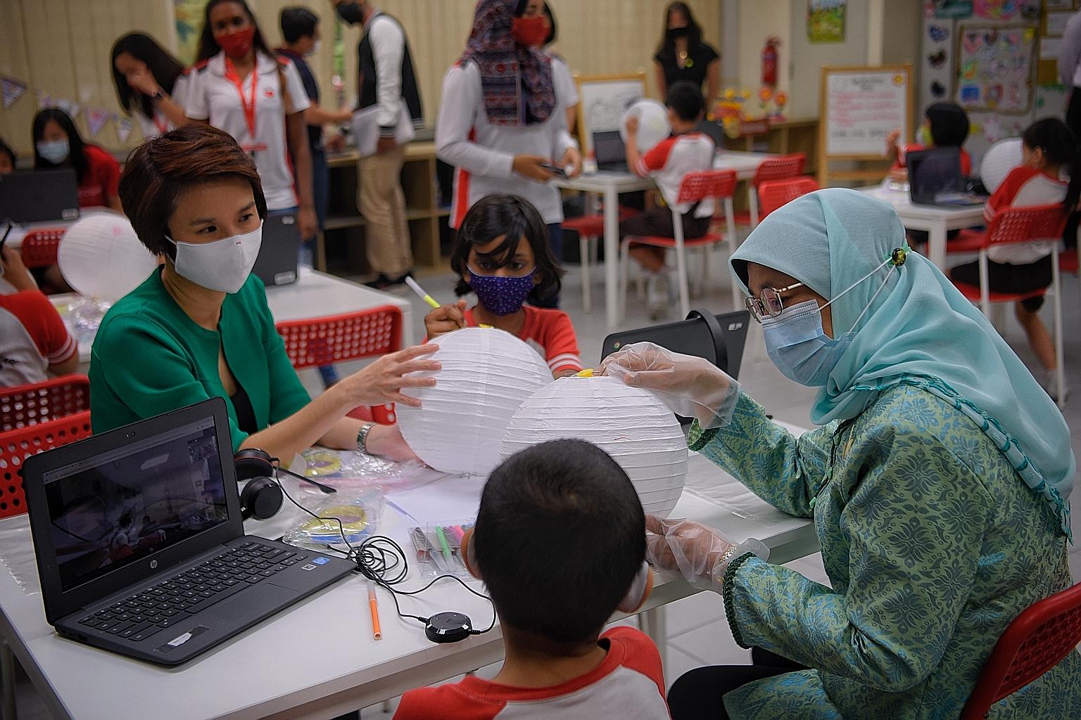President Halimah Yacob and Ms Low Yen Ling, who is Minister of State for Culture, Community and Youth, celebrating the Mid-Autumn Festival, which is today, by decorating lanterns with Boon Lay Garden Primary School pupils Sahana Kumar (with purple m