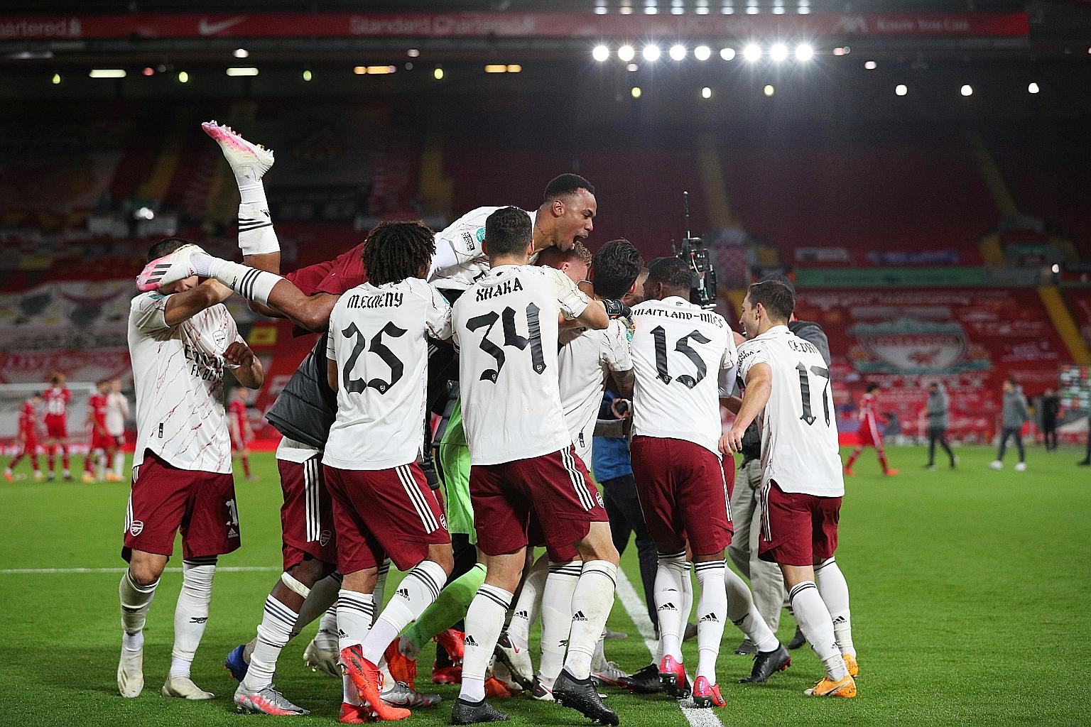 Arsenal players celebrating their 5-4 shoot-out victory over Liverpool on Thursday to progress to a League Cup quarter-final clash with holders Manchester City in late December.