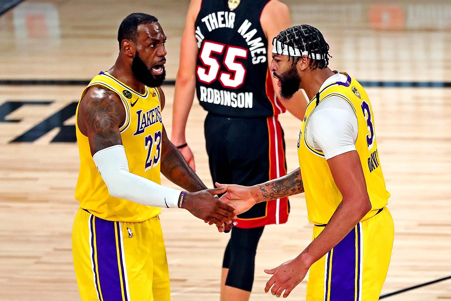 Los Angeles Lakers forwards LeBron James (left) and Anthony Davis congratulating each other during Game 1 of the NBA Finals against the Miami Heat at the AdventHealth Arena on Wednesday.