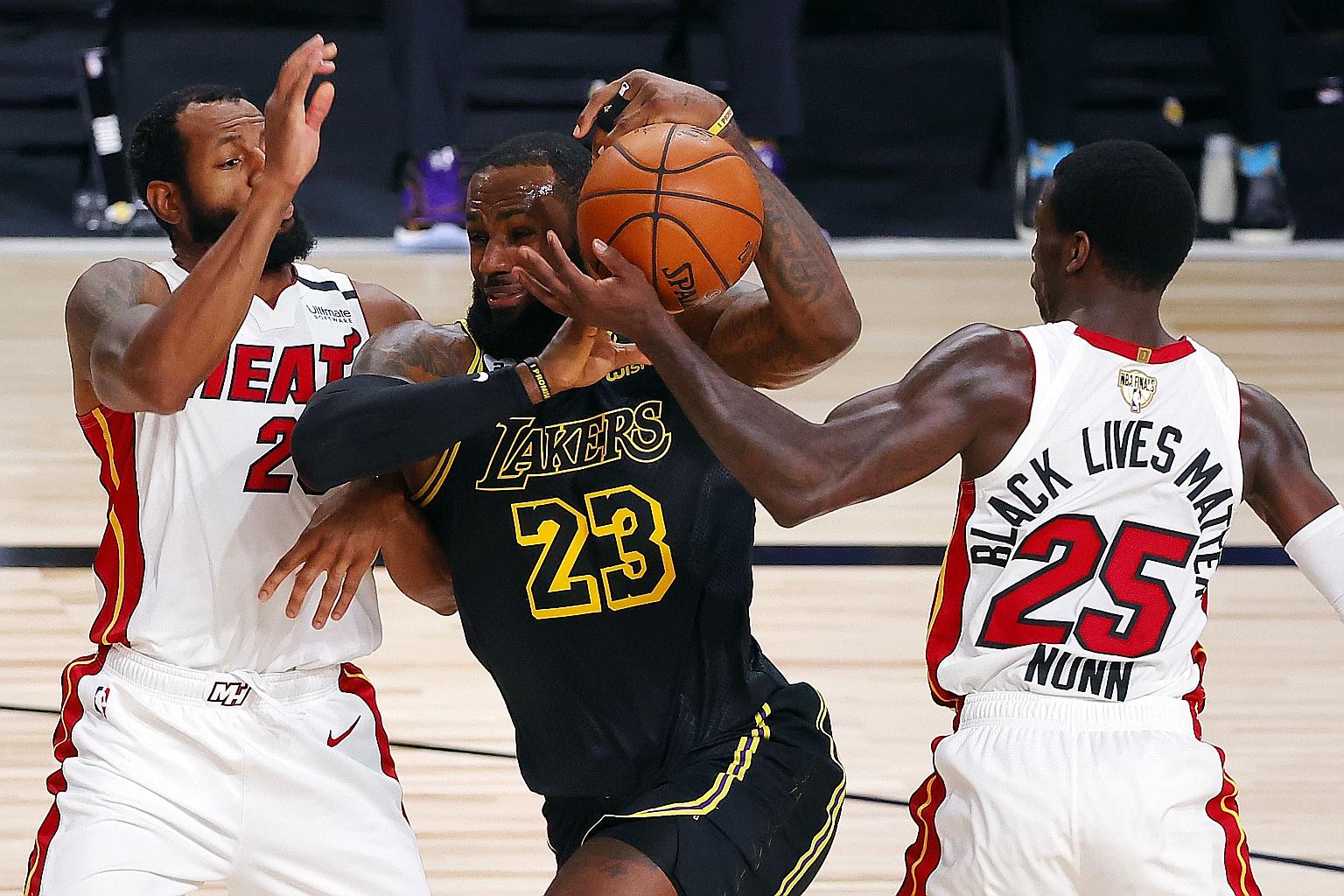 The Los Angeles Lakers' LeBron James driving to the basket between the Miami Heat's Andre Iguodala and Kendrick Nunn during the first half of Game 2 of the 2020 NBA Finals on Friday. James ended with 33 points as the Lakers won 124-114. PHOTO: AGENCE