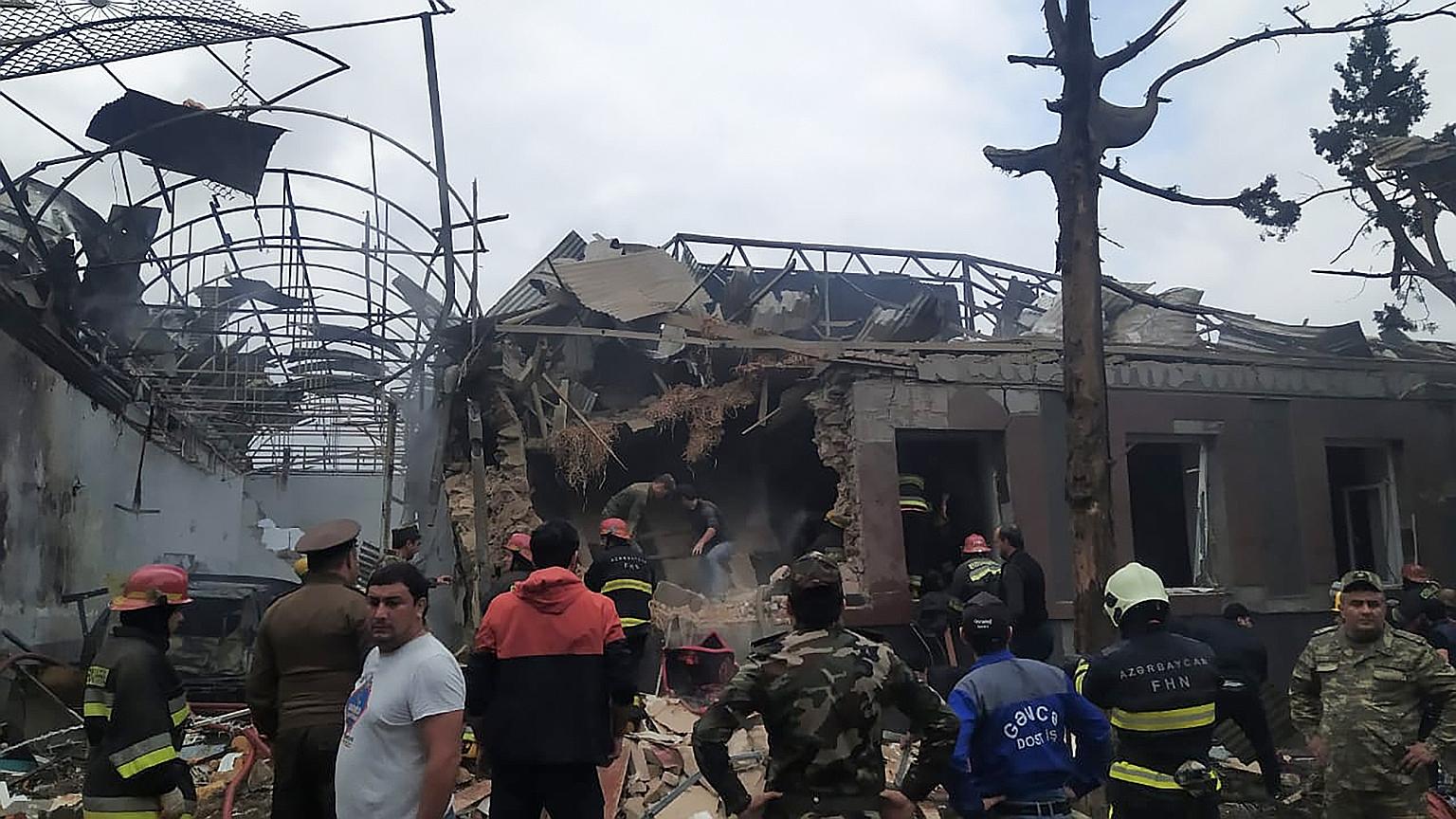 Emergency personnel working in a damaged area of Ganja. Armenia yesterday said it struck a military airport in Azerbaijan's second largest city during the ongoing fighting between the two former Soviet republics over the breakaway Nagorno-Karabakh re