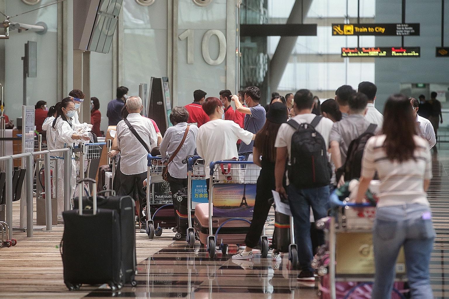 Travellers queueing up for temperature taking before checking in for their flights at Changi Airport Terminal 3 last month. Deputy Prime Minister Heng Swee Keat said Transport Minister Ong Ye Kung will deliver a ministerial statement on reviving Sing