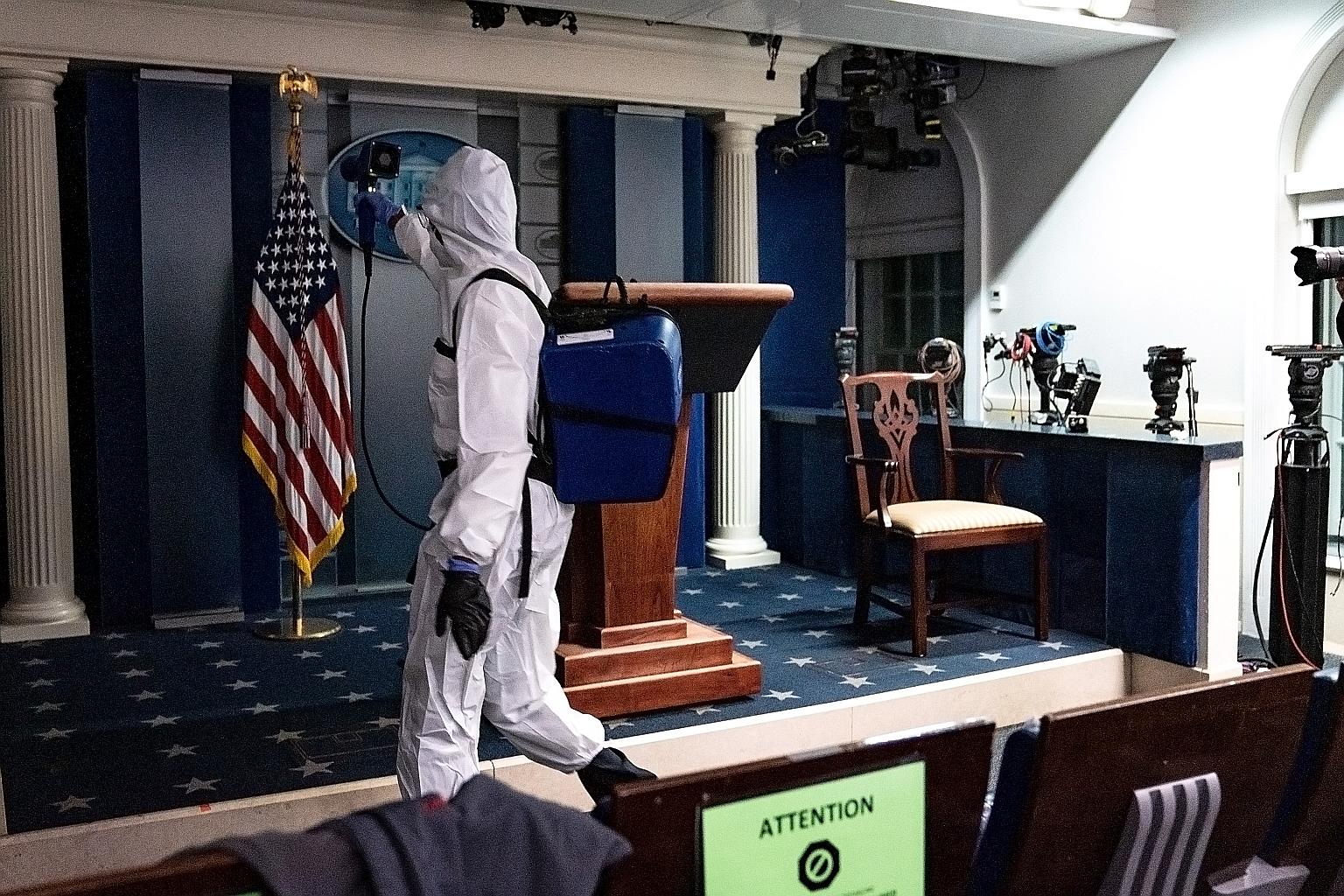 A member of the White House cleaning staff spraying disinfectant in the James S. Brady Press Briefing Room in the White House on Monday.