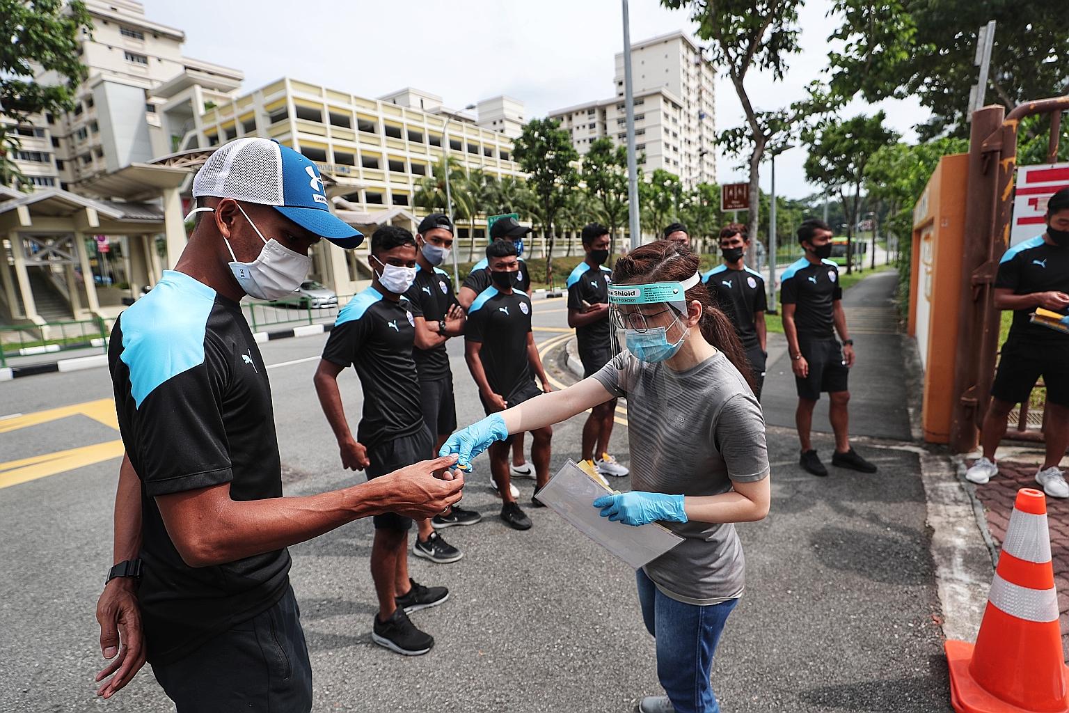 Lion City Sailors defender Tajeli Salamat receiving a sticker before entering the swab test centre.