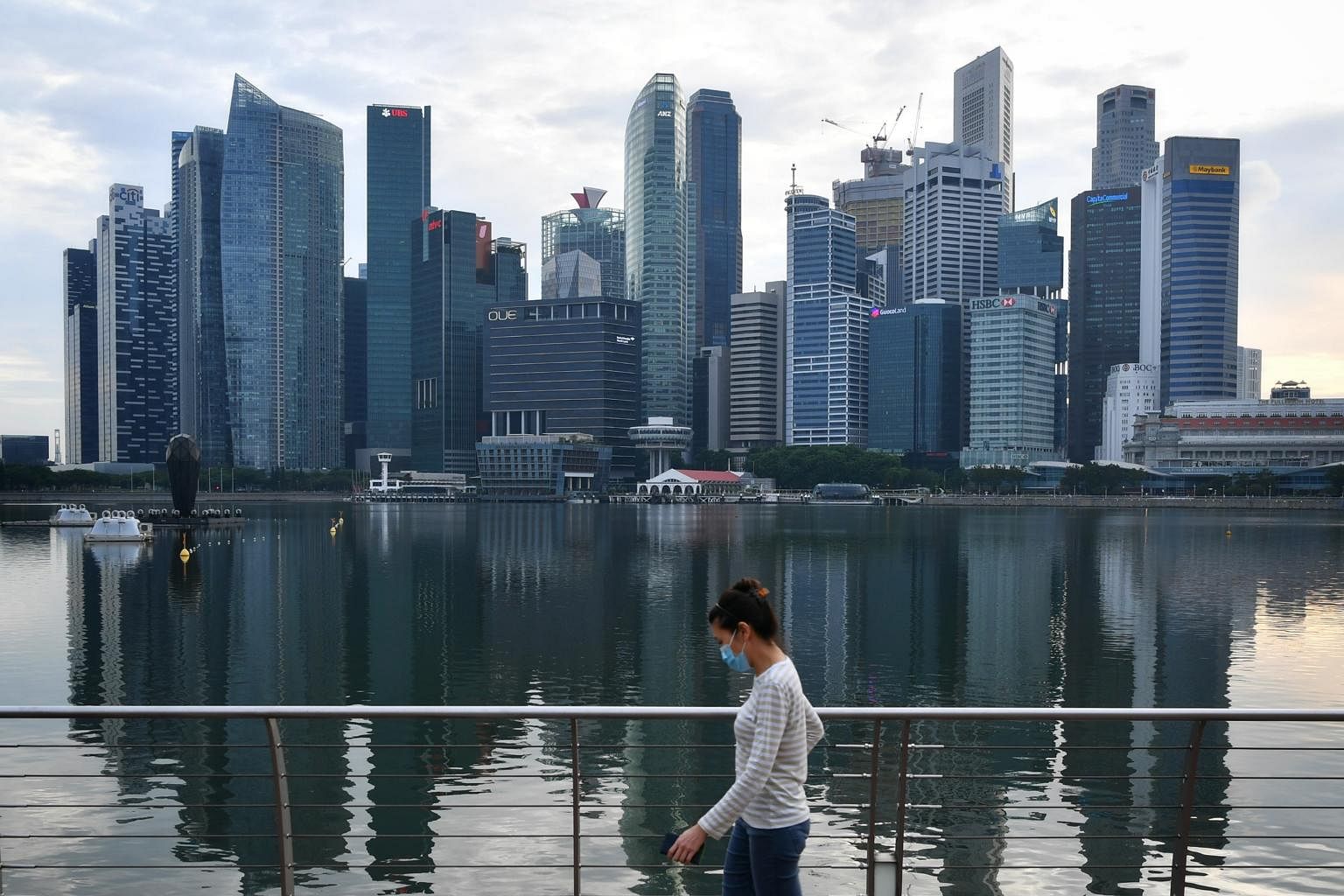 A woman walks at the waterfront promenade outside Marina Bay Sands on June 6, 2020.