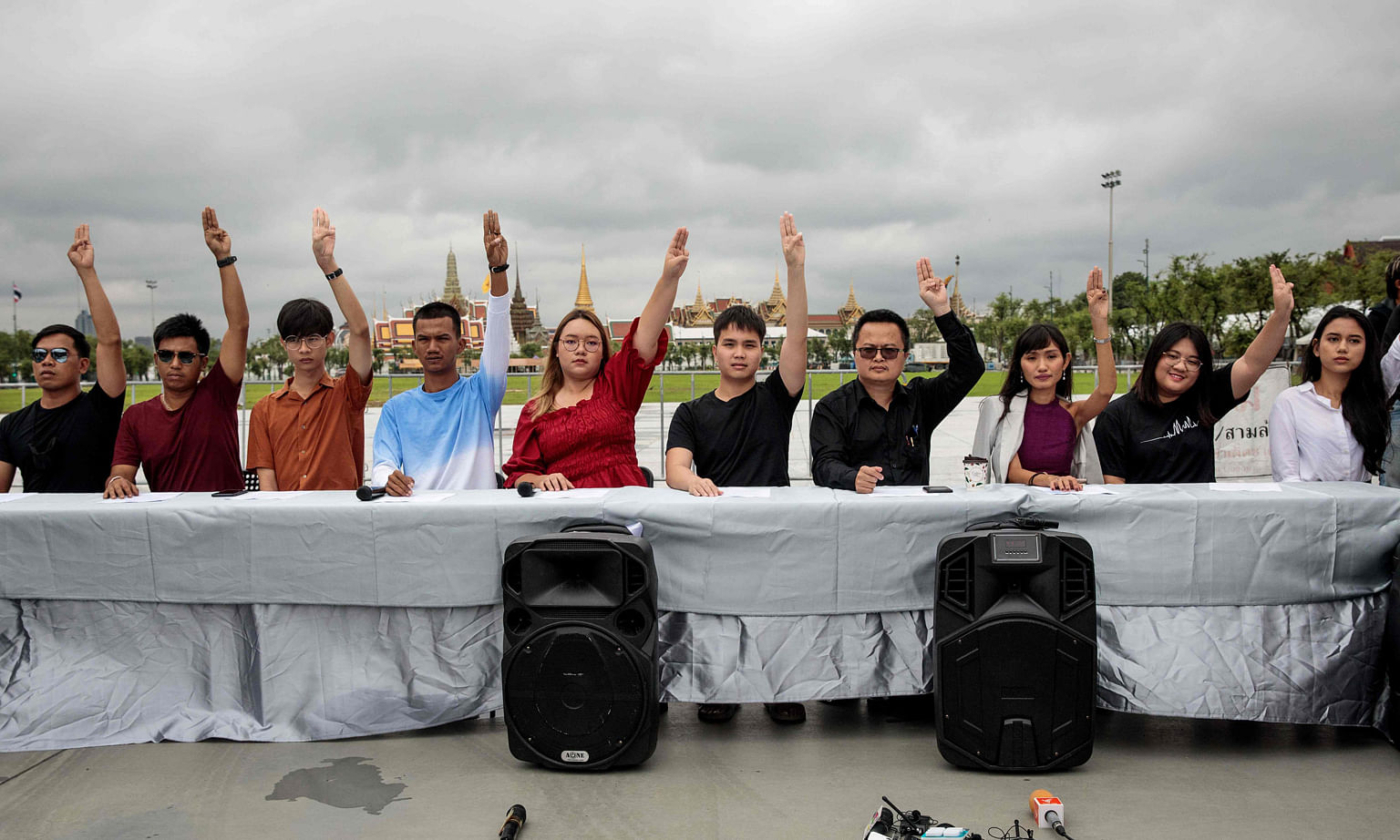 Thai pro-democracy leaders making a three-finger salute as a general symbol against dictatorship, at a press conference across from the Grand Palace in Bangkok yesterday, ahead of a planned rally next week.