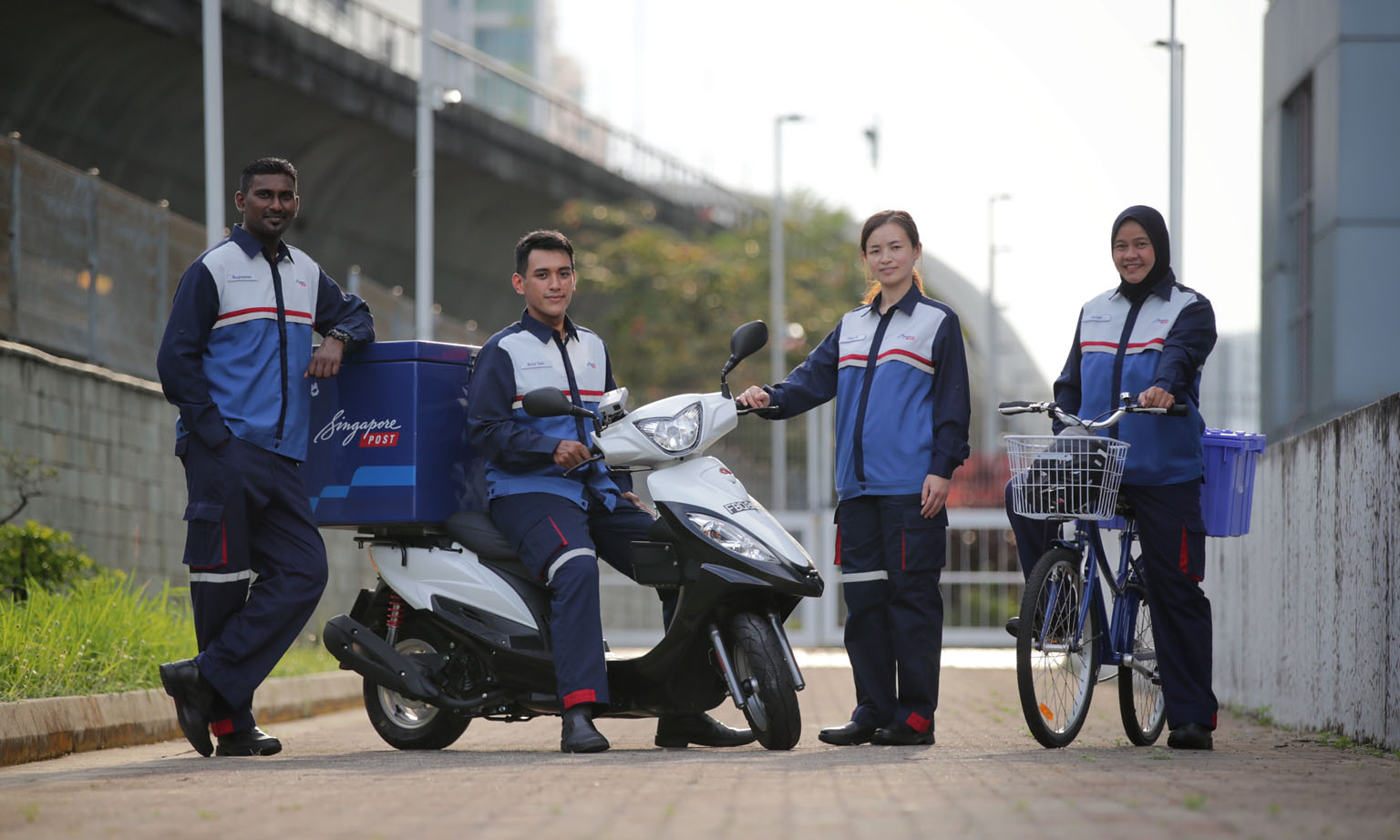 From left: SingPost staff Mageswaran Arumugam, 37; Muhammad Aizuddin Musa, 26; Huo Xiang Xiu, 28; and Paridah Ismail, 51, wearing the new uniform for postmen at the SingPost Centre Regional Base on Wednesday. The new uniform features its corporate colours