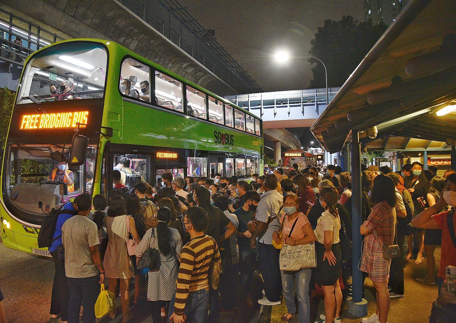 The scene outside Queenstown MRT station yesterday evening as train commuters waited to board free bus services. There were no train services on parts of the North-South and East-West lines at about 7pm, and later on the Circle Line at 7.30pm, in wha