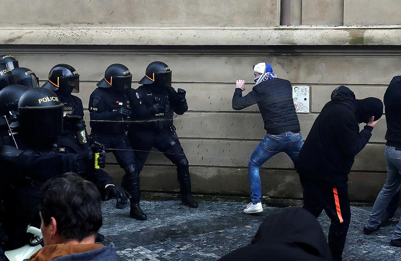 A riot police officer in a face-off with a protester during a rally in Prague on Sunday against social distancing rules and government measures to stem the spread of Covid-19. The Czech Republic faces Europe's worst spread of the disease.