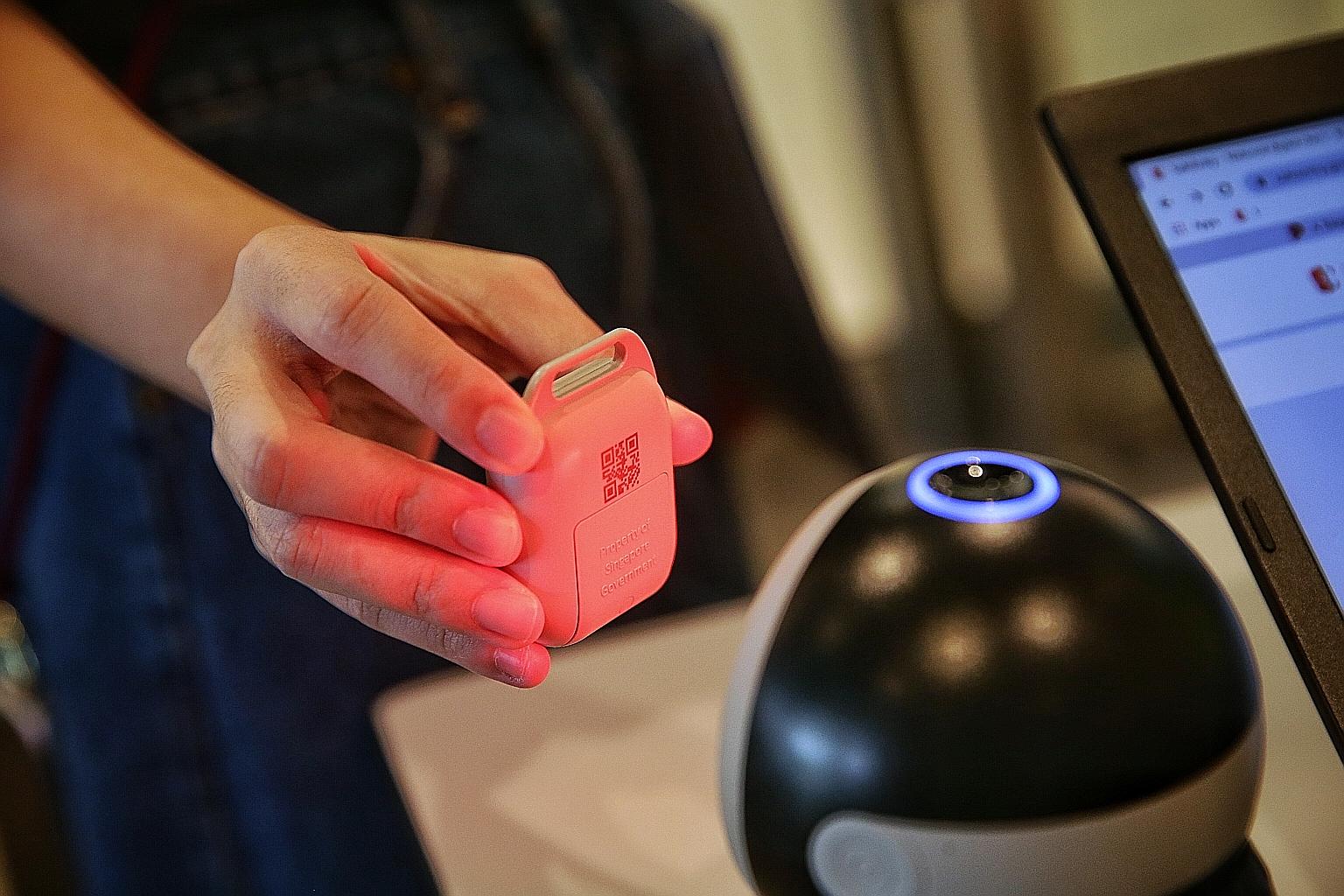 The TraceTogether app has a function for scanning SafeEntry QR codes, while the tokens (above) sport a QR code with a similar function.