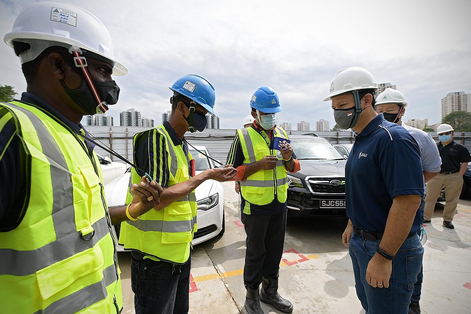 Senior Minister of State for Manpower Zaqy Mohamad (right) speaking with migrant workers while visiting a construction worksite at the Chinese Garden yesterday. As part of safe management measures amid the coronavirus pandemic, the workers each wear