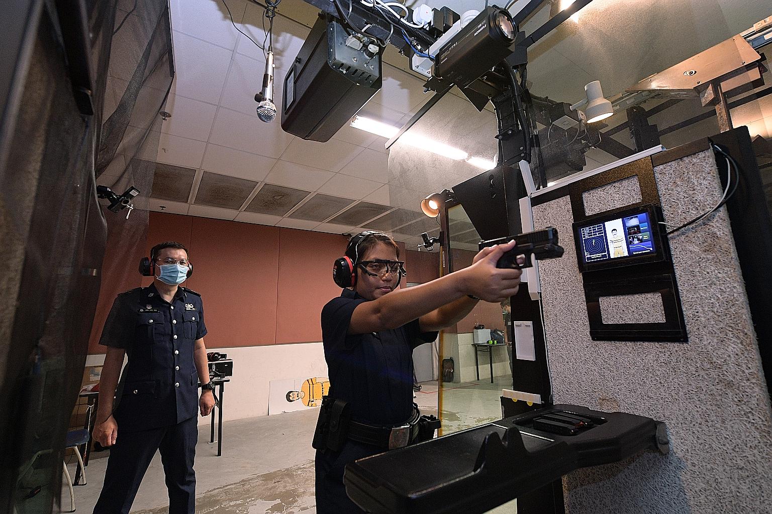 Senior Staff Sergeant Ang Eng Hau (left) observing trainee Noorafidah Mohamed Nasar during a demonstration of the Enhanced Live Firing Range System at the Home Team Academy last Wednesday.
