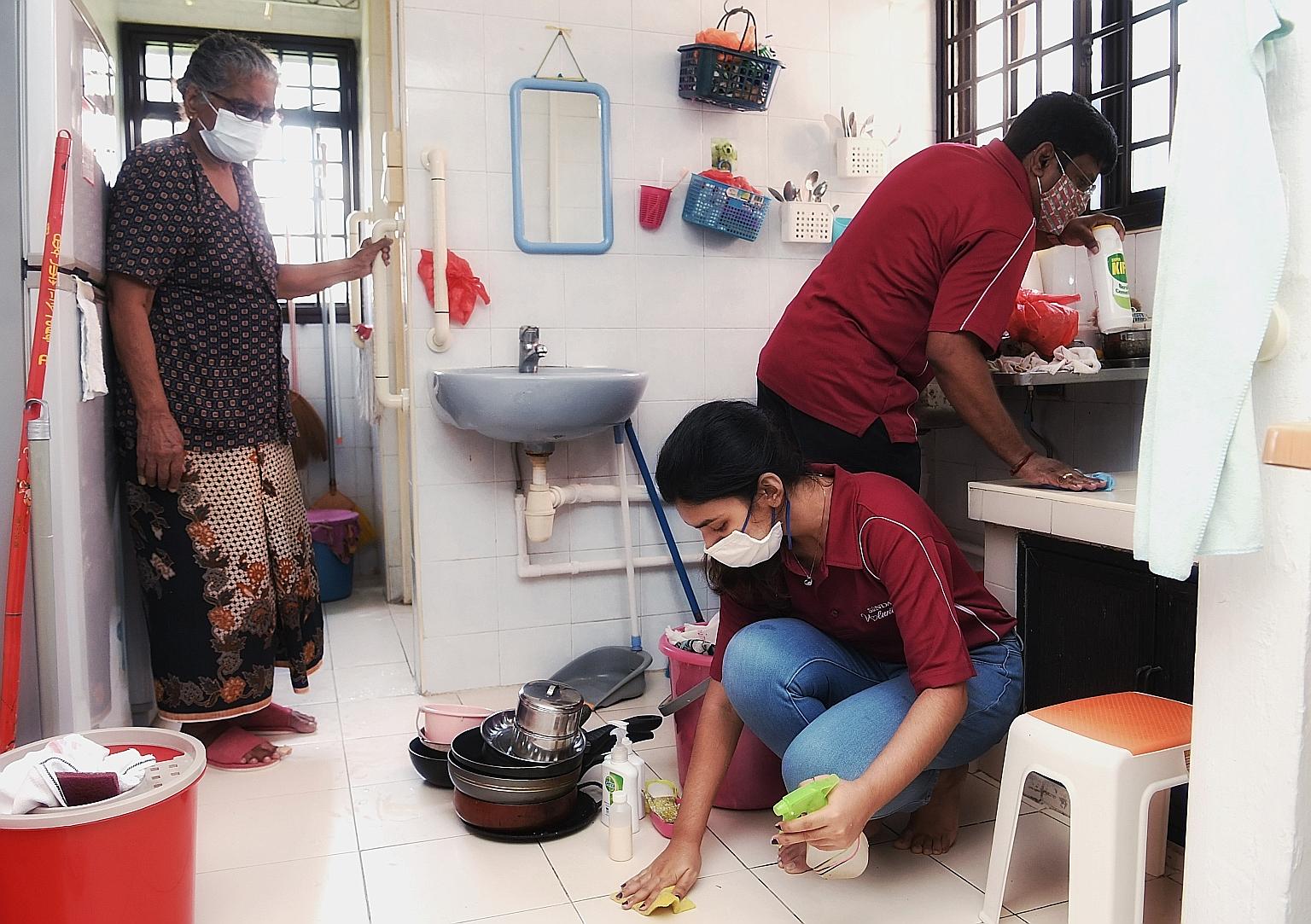 Madam Govindamal Mariappan, 89, watching volunteers clean her home in Bukit Merah yesterday. More than 50 of them from the Singapore Indian Development Association and Young Sikh Association took part in a new initiative, known as Project Shine, to h