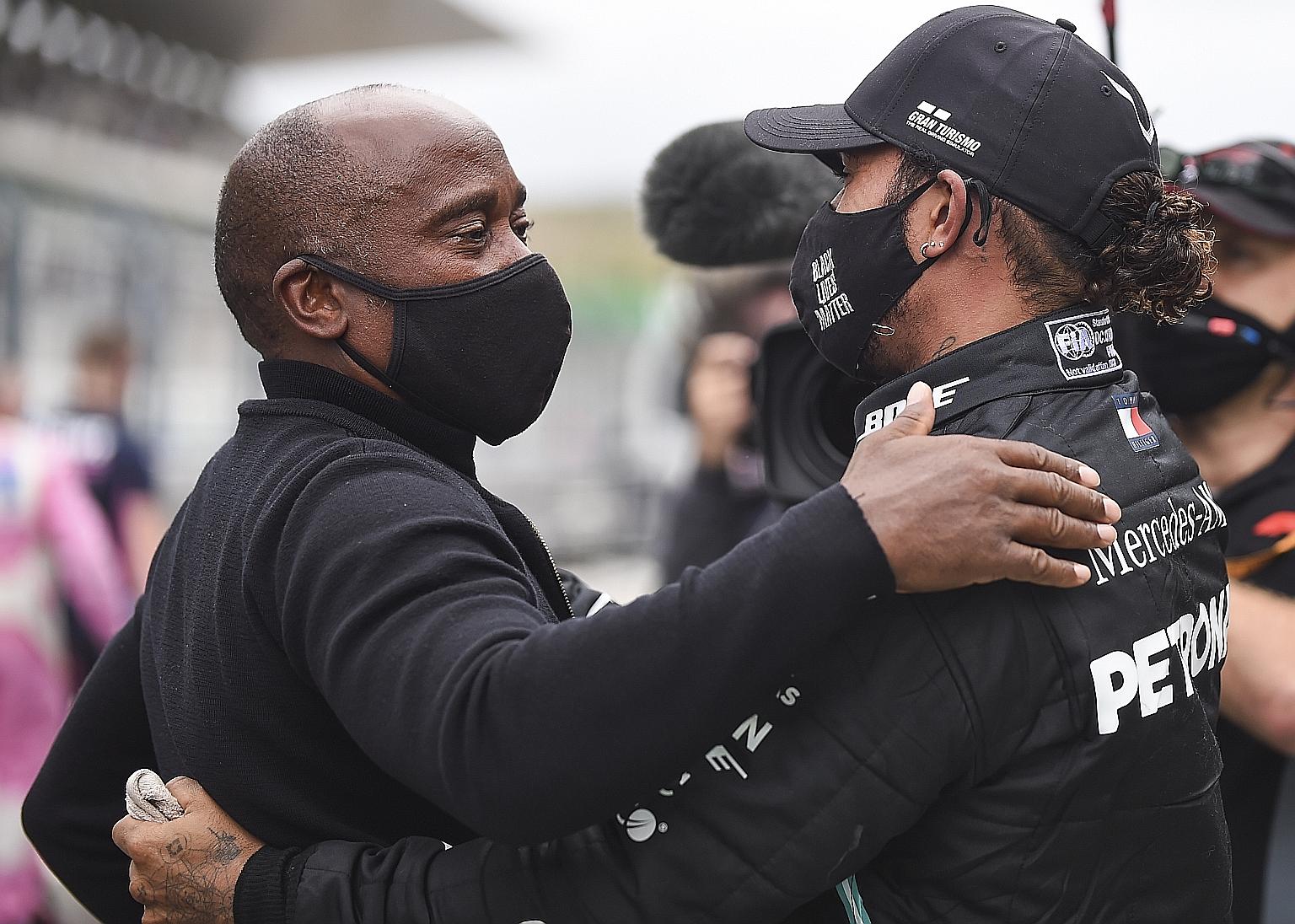 Six-time Formula One champion Lewis Hamilton and his father, the man behind his success, hug after he won the first Portuguese Grand Prix in 24 years yesterday at the Algarve circuit. PHOTO: EPA-EFE