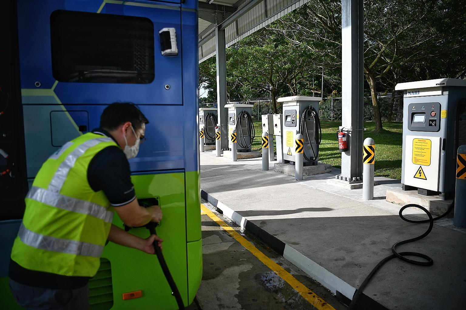 A Land Transport Authority officer showing how a fully electric double-decker bus is charged at Bulim Bus Depot in Jurong yesterday.