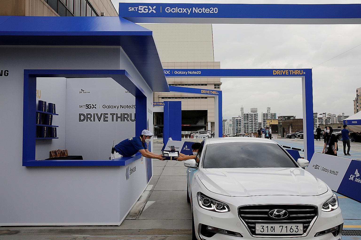 A visitor collecting a Samsung Galaxy Note 20 smartphone during a driving-through event for purchasers in Seoul on Aug 13. Sales of Samsung smartphones jumped nearly 50 per cent during the September quarter as the roll-out of its latest Galaxy Note s
