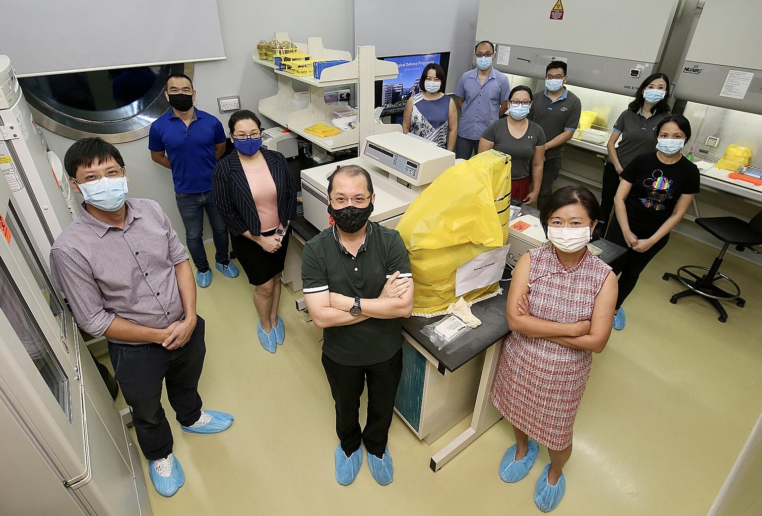 Associate Professor Tan Boon Huan (front row, right), director of DSO National Laboratories' biological defence programme, with members of her winning team at a DSO lab in Kent Ridge. She said her team's role in the national Covid-19 effort was the r