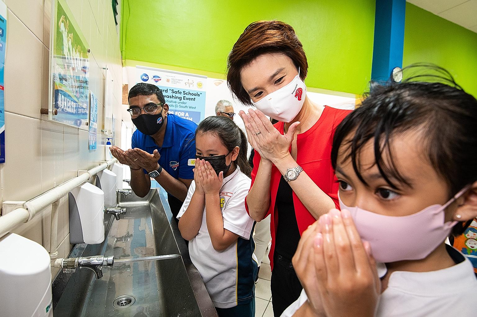 Mayor of South West District Low Yen Ling participating in a hand-washing demonstration on Thursday with pupils from Lianhua Primary School. With them is Mr Shankar Viswanathan, Procter & Gamble (P&G) senior vice-president for Malaysia, Singapore and