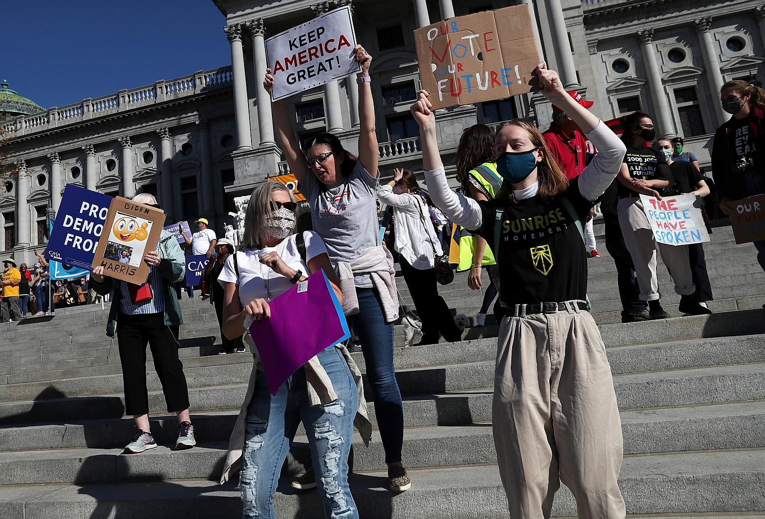 Supporters of Democratic presidential nominee Joe Biden celebrating yesterday outside the state Capitol building in Harrisburg, Pennsylvania. PHOTO: REUTERS