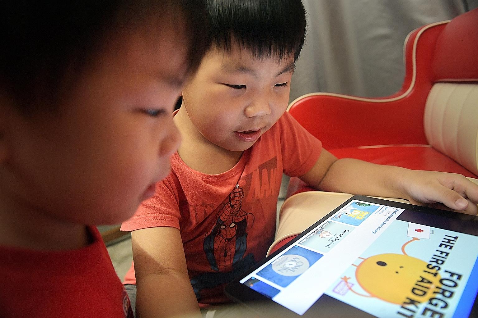 Brothers Alexander, three, (far left and right) and George Chern, six, enjoy reading both physical books and e-books. Although e-books may be more entertaining, experts say nothing beats good old printed books for stimulating the brain.