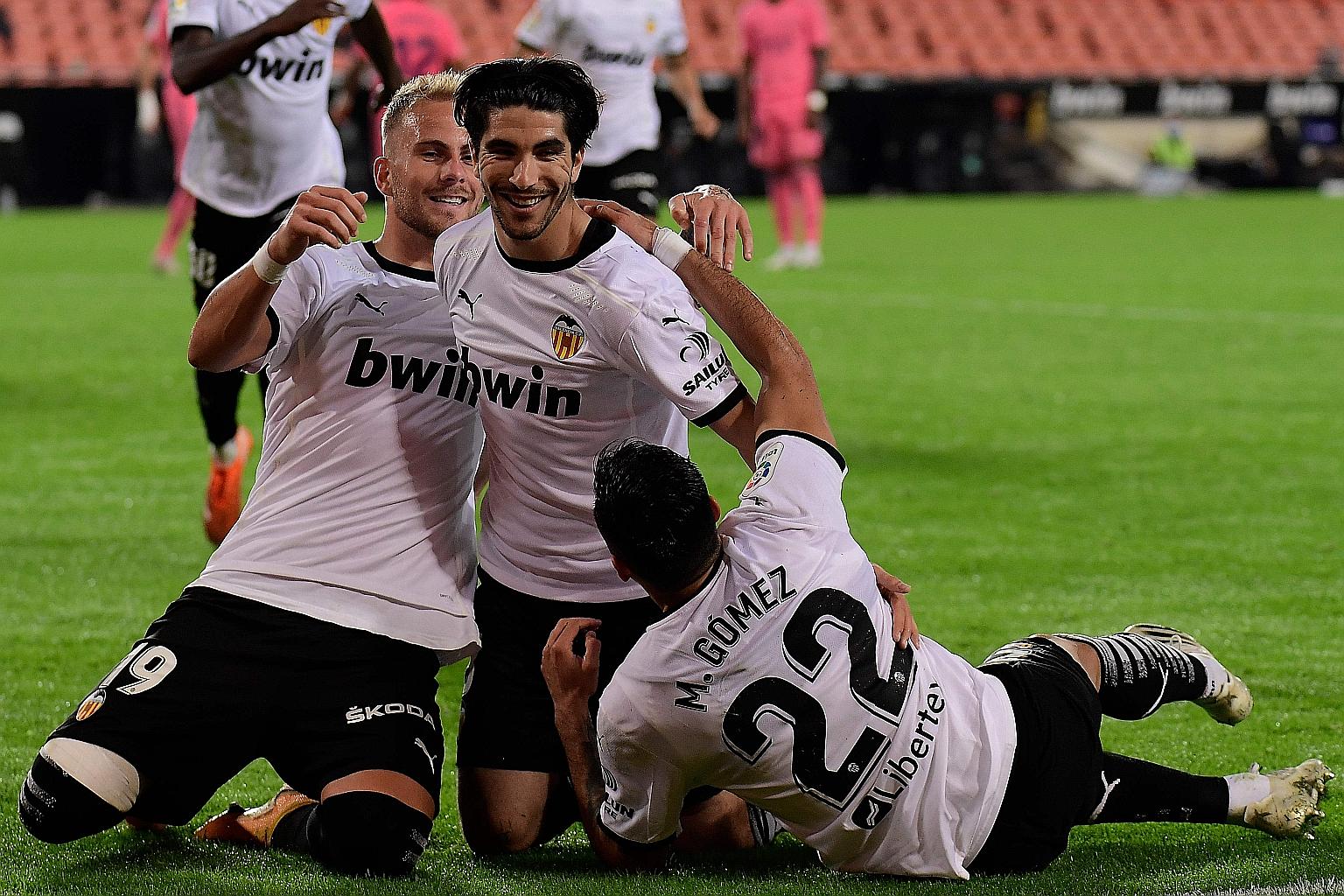 Carlos Soler (centre) celebrating with Valencia teammates Uros Racic and Maxi Gomez after scoring one of his three penalties against Real Madrid in Sunday's 4-1 win at the Mestalla stadium.