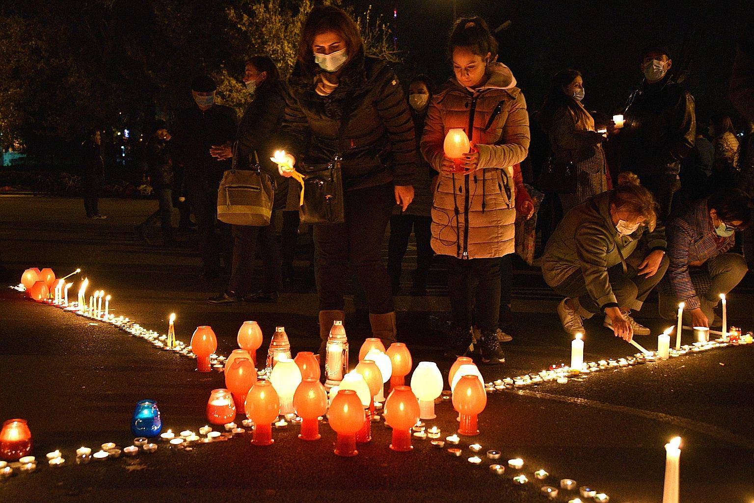 People lighting candles in memory of Armenians killed in the military conflict between Armenia and Azerbaijan over the disputed Nagorno-Karabakh region, during a demonstration last Saturday in Yerevan against a controversial peace deal with Azerbaija
