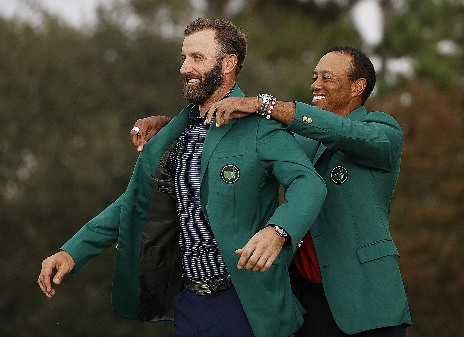 Tiger Woods putting the green jacket on fellow American Dustin Johnson after the 36-year-old broke the 72-hole Masters record of 270 previously held by Jordan Spieth and him.