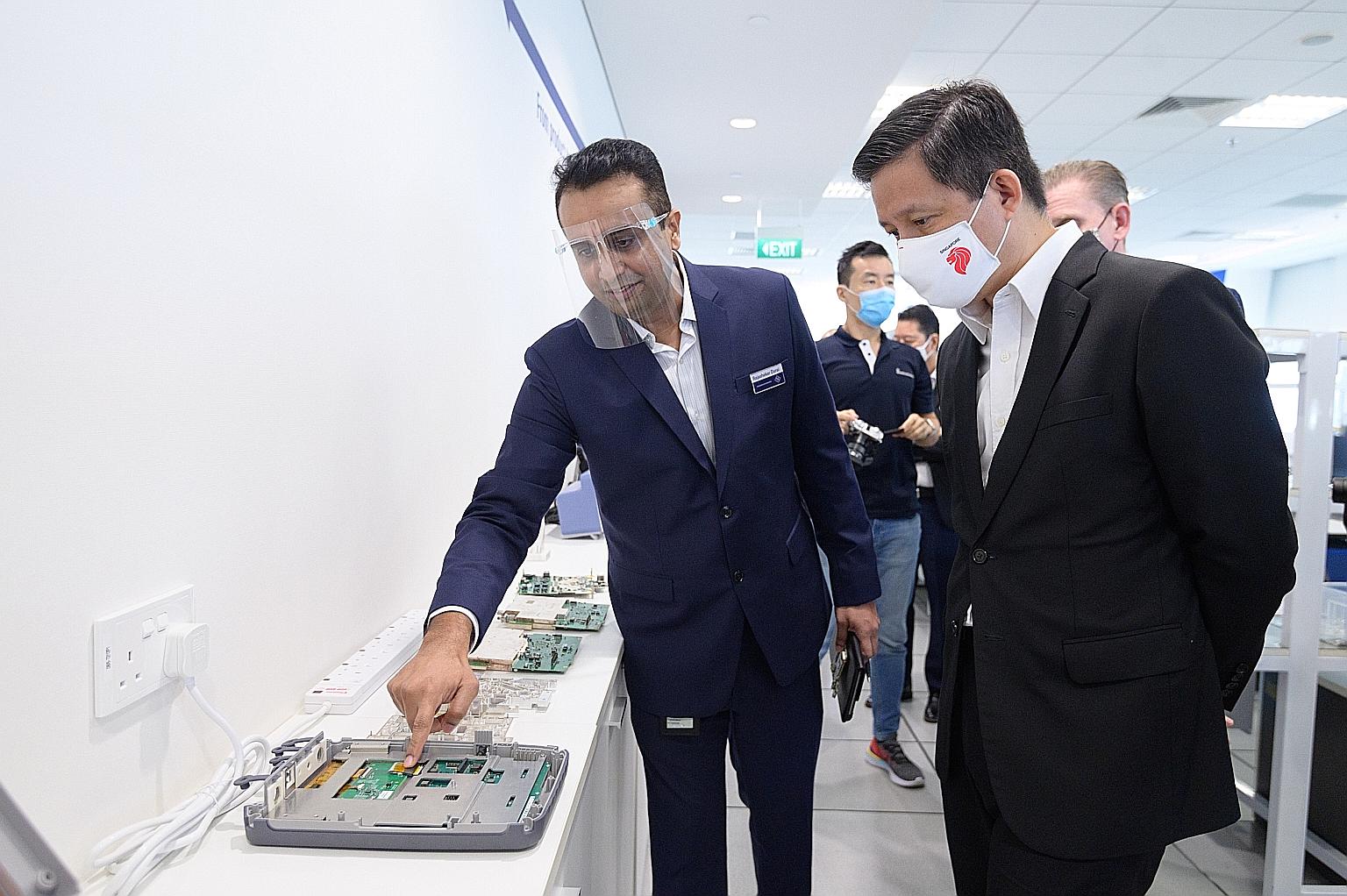 Trade and Industry Minister Chan Chun Sing visiting German technology group Rohde & Schwarz at Changi yesterday. Beside him is the firm's senior director of R&D Rajashekar Durai. The sector will benefit from new enhancements to a scheme that helps co