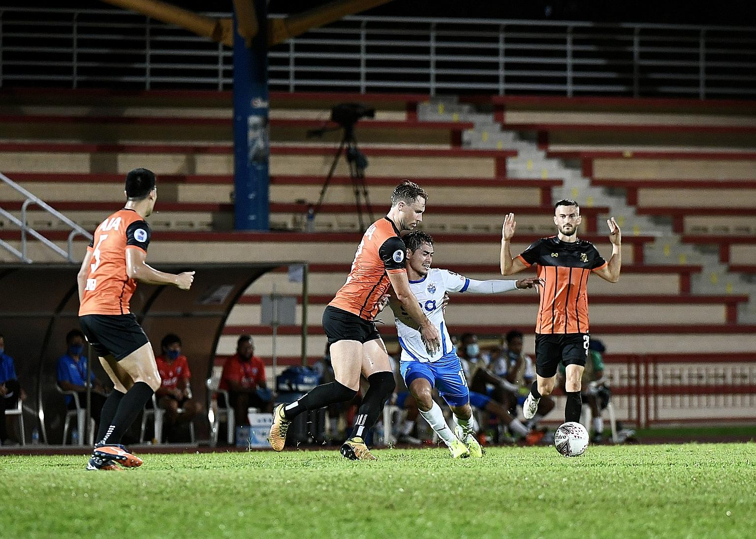Hougang's Zac Anderson and Lion City's Gabriel Quak fighting for the ball in the penalty box during yesterday's SPL match at Hougang Stadium. Quak opened the scoring with a 12th-minute free kick.