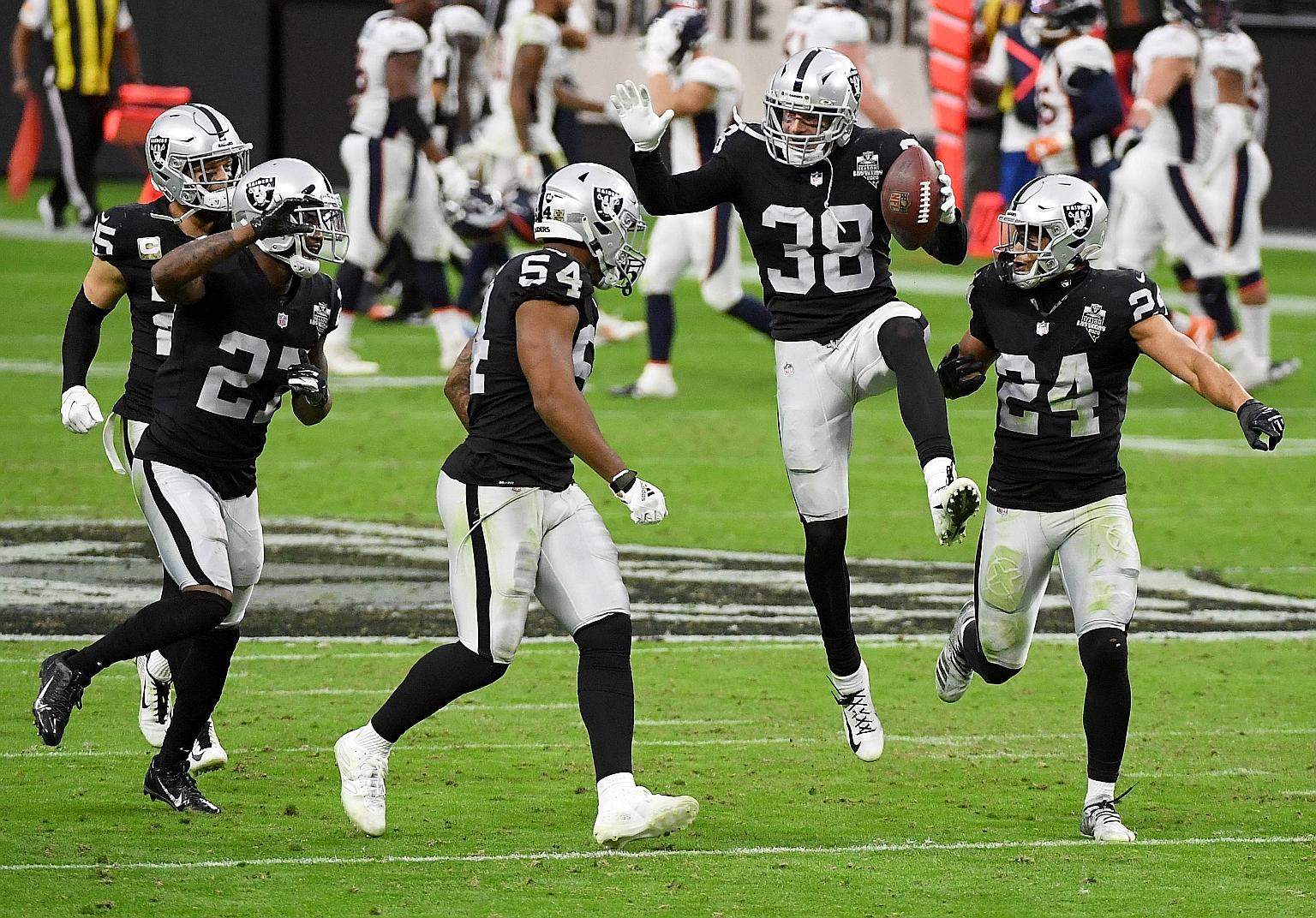 Las Vegas Raiders' players celebrating an interception during their 37-12 win over the Denver Broncos last Sunday. On Wednesday, the Raiders added seven more players to the Covid-19 reserve list, including Johnathan Abram (right), amid a coronavirus 
