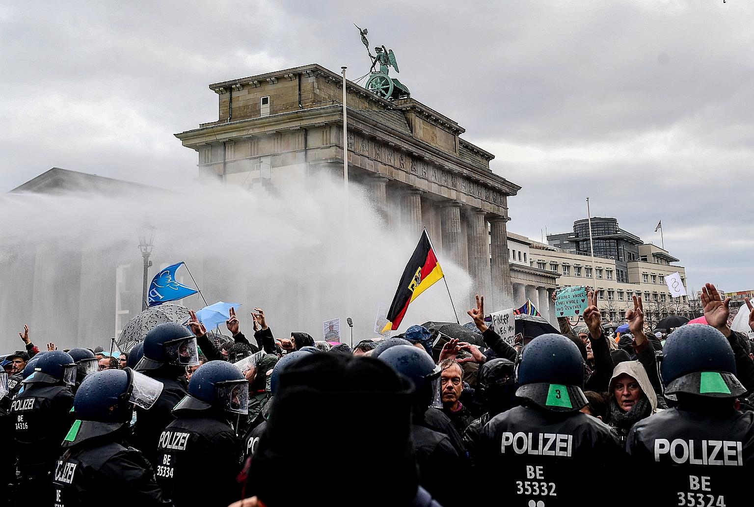 Riot police using a water cannon to break up a demonstration against Germany's coronavirus restrictions, near Berlin's Brandenburg Gate, on Wednesday. Two weeks into a partial shutdown, contagion rates in the country are still nearly triple the level