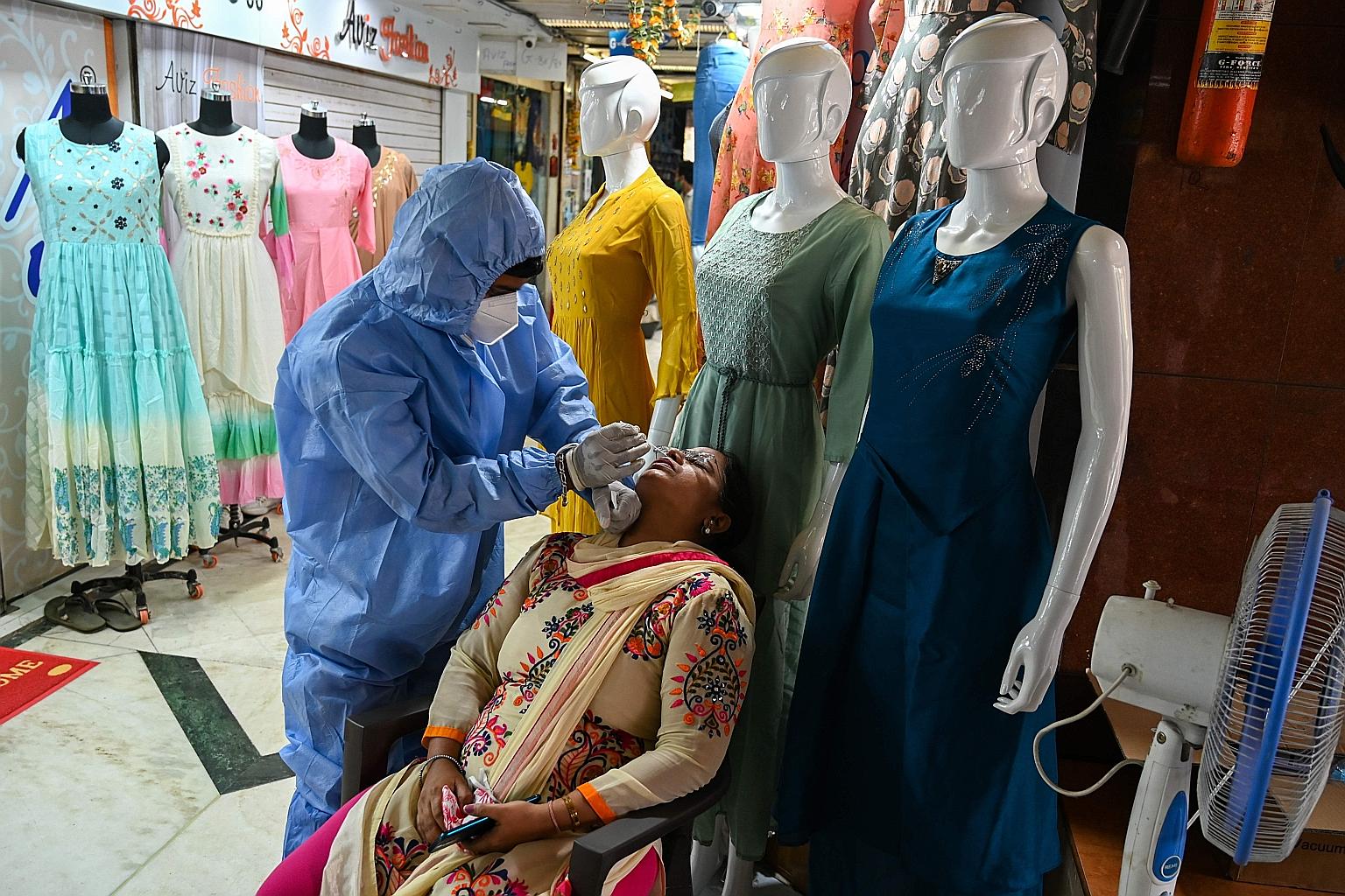 A health worker taking a swab during a screening at a garment wholesale market in Mumbai yesterday. India reports about 45,000 new cases on average every day. PHOTO: AGENCE FRANCE-PRESSE