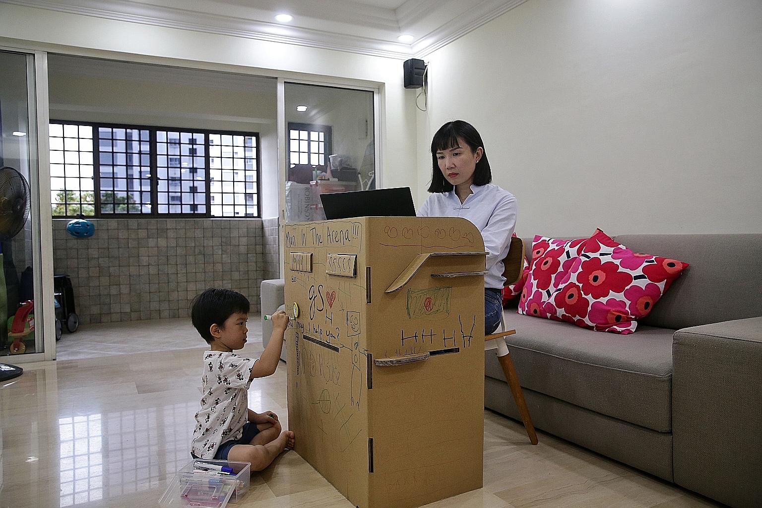 Accenture senior manager Gigi Su, 37, working from home as her son Zachary Wu, five, doodled on her cardboard work desk on Friday.