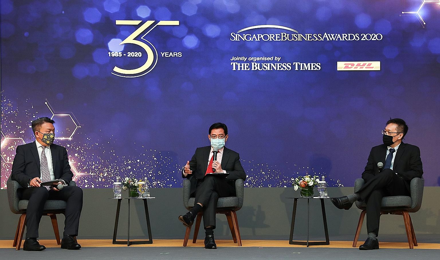 Deputy Prime Minister Heng Swee Keat speaking at the 35th Singapore Business Awards, held at Singapore Press Holdings' News Centre auditorium yesterday. His fellow panellists were DHL Express Singapore managing director Christopher Ong (left) and Bus