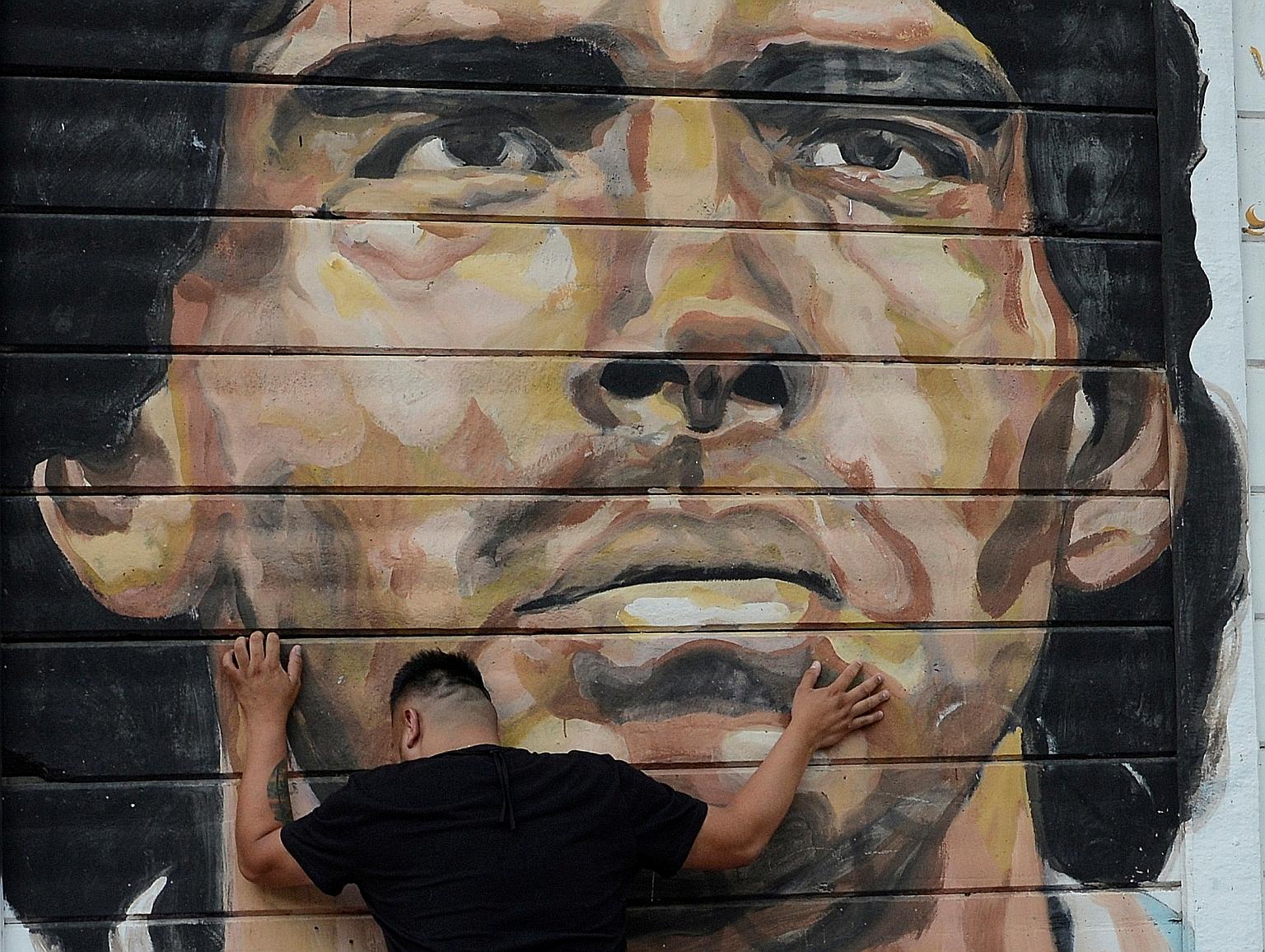 A fan in mourning outside the Diego Armando Maradona Stadium in Buenos Aires. PHOTO: REUTERS SEE THE BIG STORY A14, SPORT B25&26